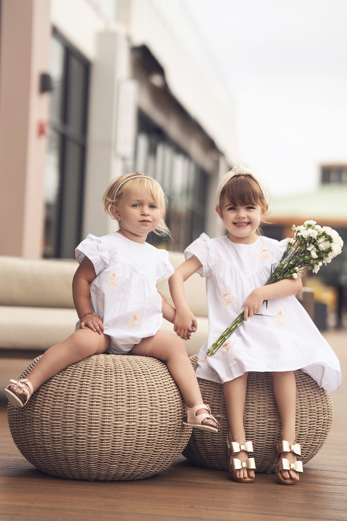 Child with a toy binoculars at the beach, lighthouse in background on a sunny day.