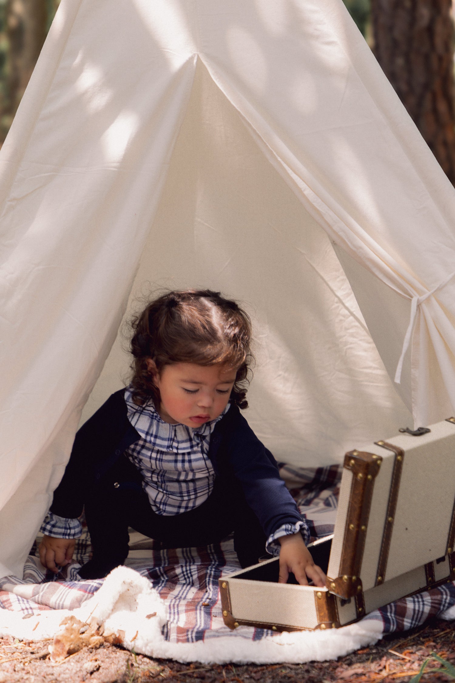 Two adorable infants wearing soft baby rompers, playing with toys on a cozy floor, showcasing stylish baby apparel.