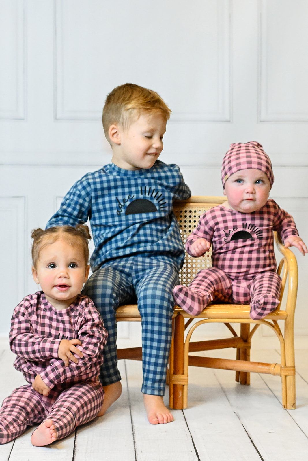 Toddler wearing black pajamas, holding a magnifying glass, playing in a cozy living room setting.