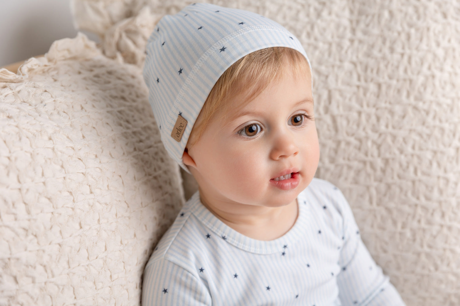 Infant wearing a floral baby beanie hat, showcasing style and warmth for colder weather.