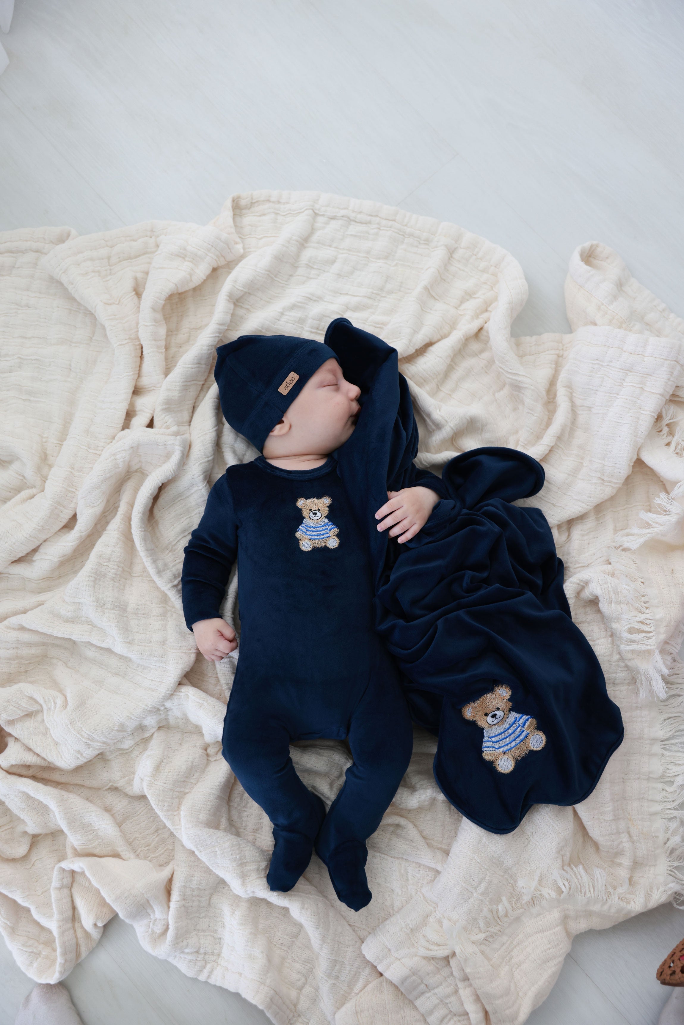 Newborn baby in floral layette set wearing a bonnet, showcasing comfort and style.
