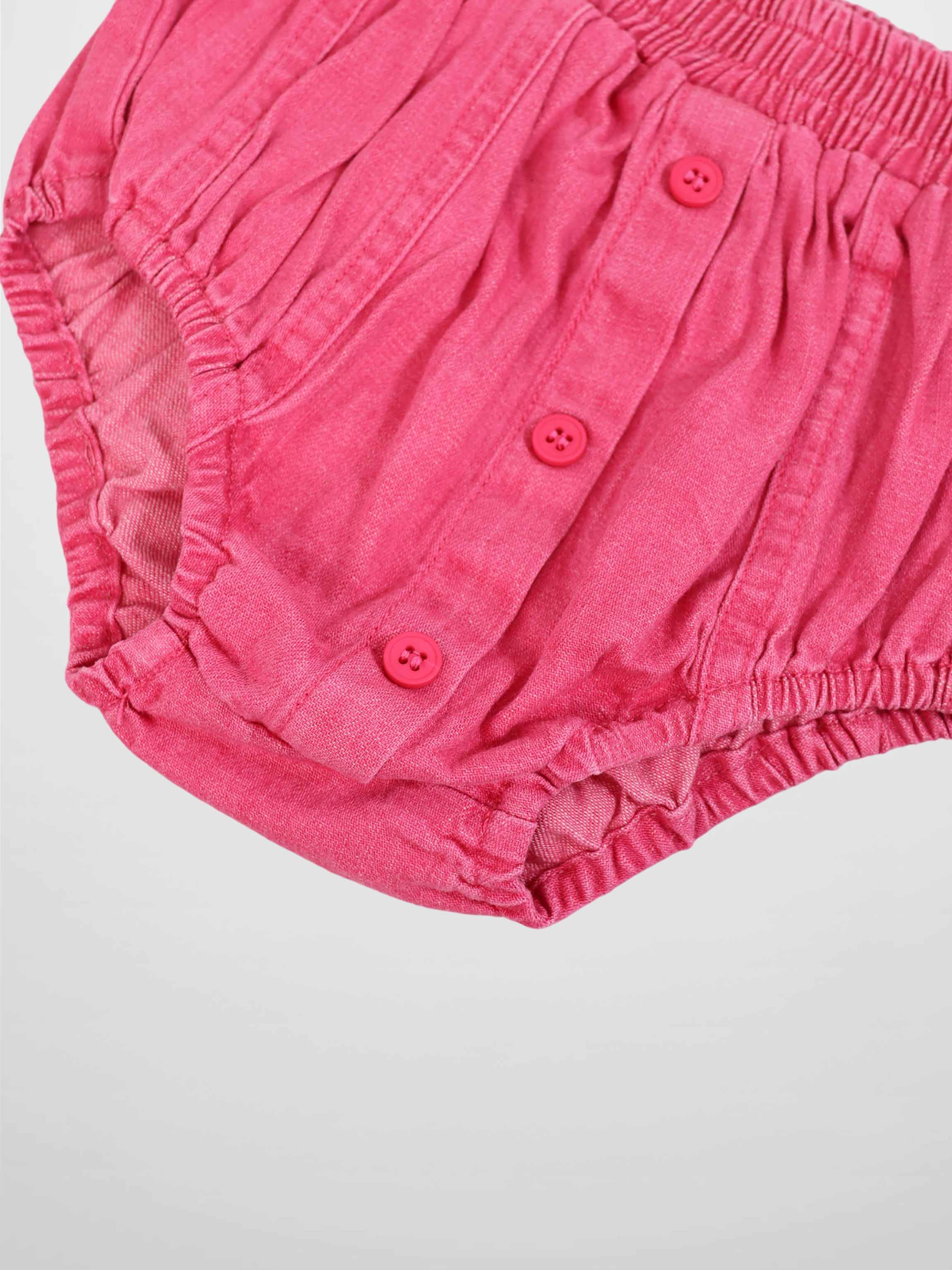 Paneled pink denim bloomers with elastic waist and pink button placket.