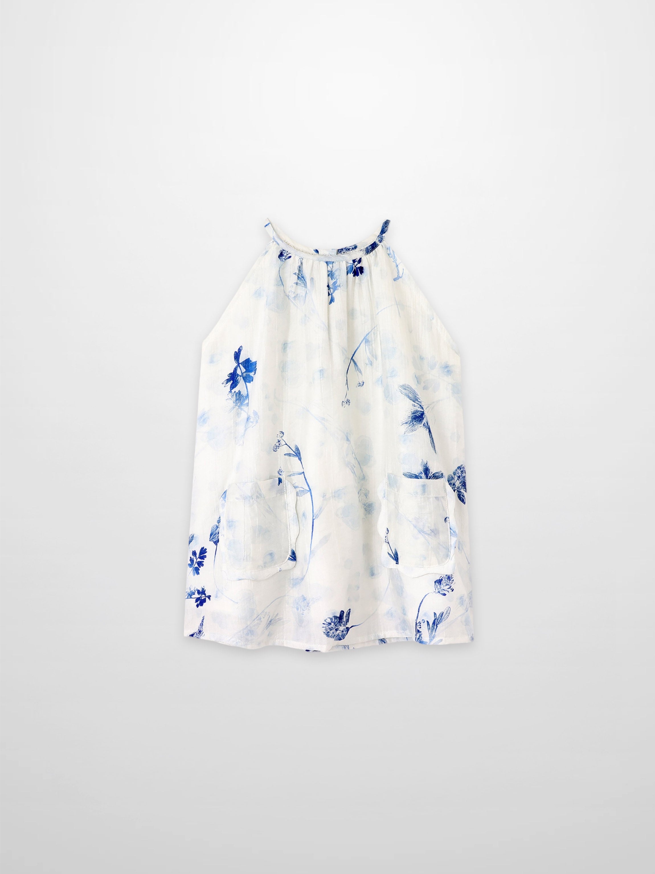 Blue Flower Jumper dress by Adee; white fabric with blue floral print and front pockets.