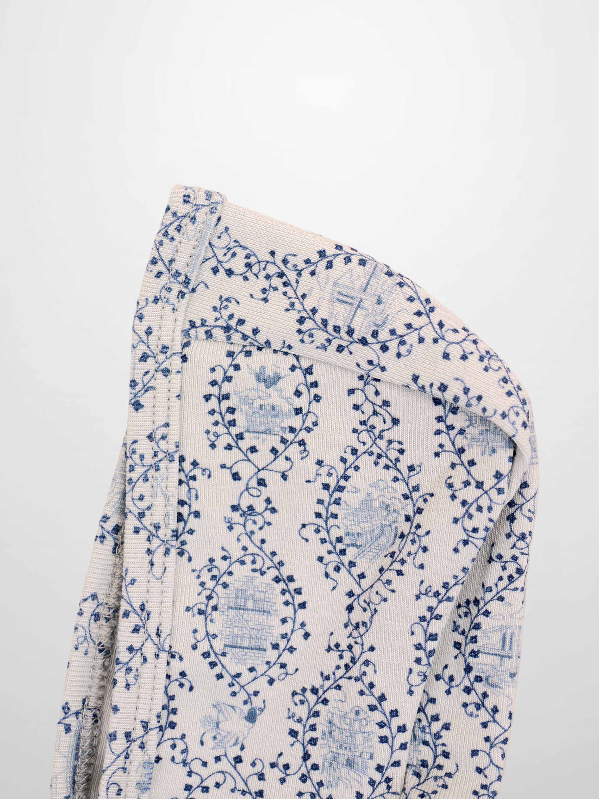 Blue Charm Bonnet for boys by Adee; beige knit fabric with dark blue vine pattern.