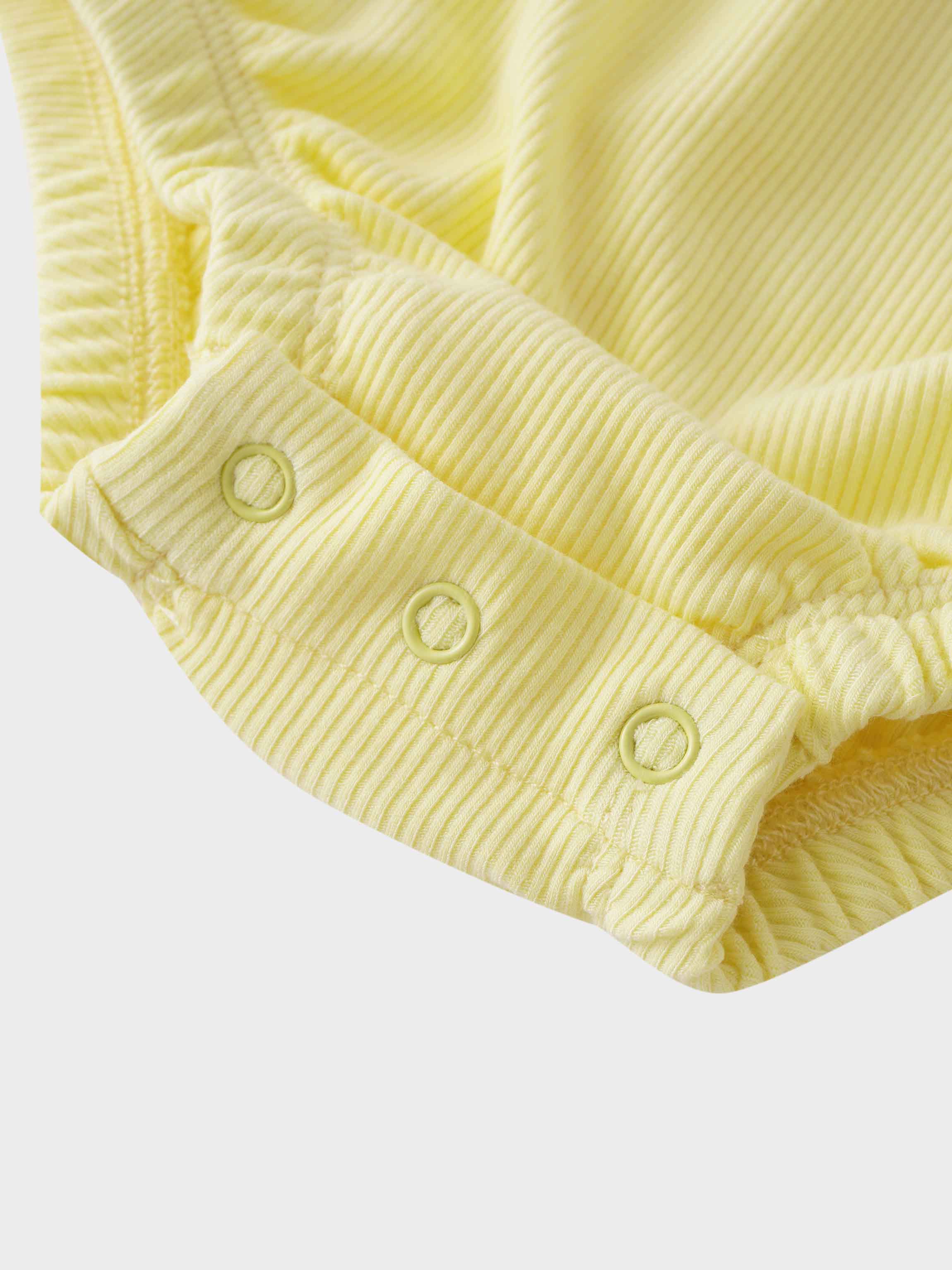 Close-up of yellow romper buttons