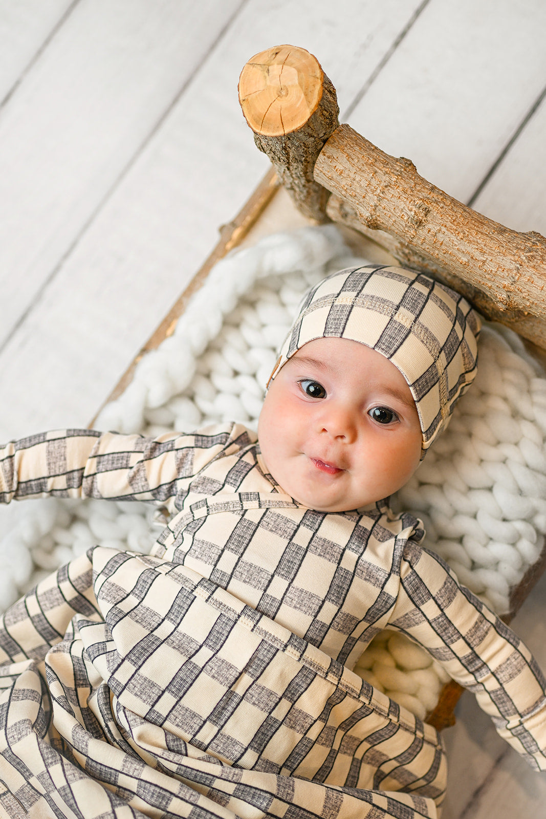 cute baby boy wearing a jumpsuit with a beanie hat with swaddle blanket