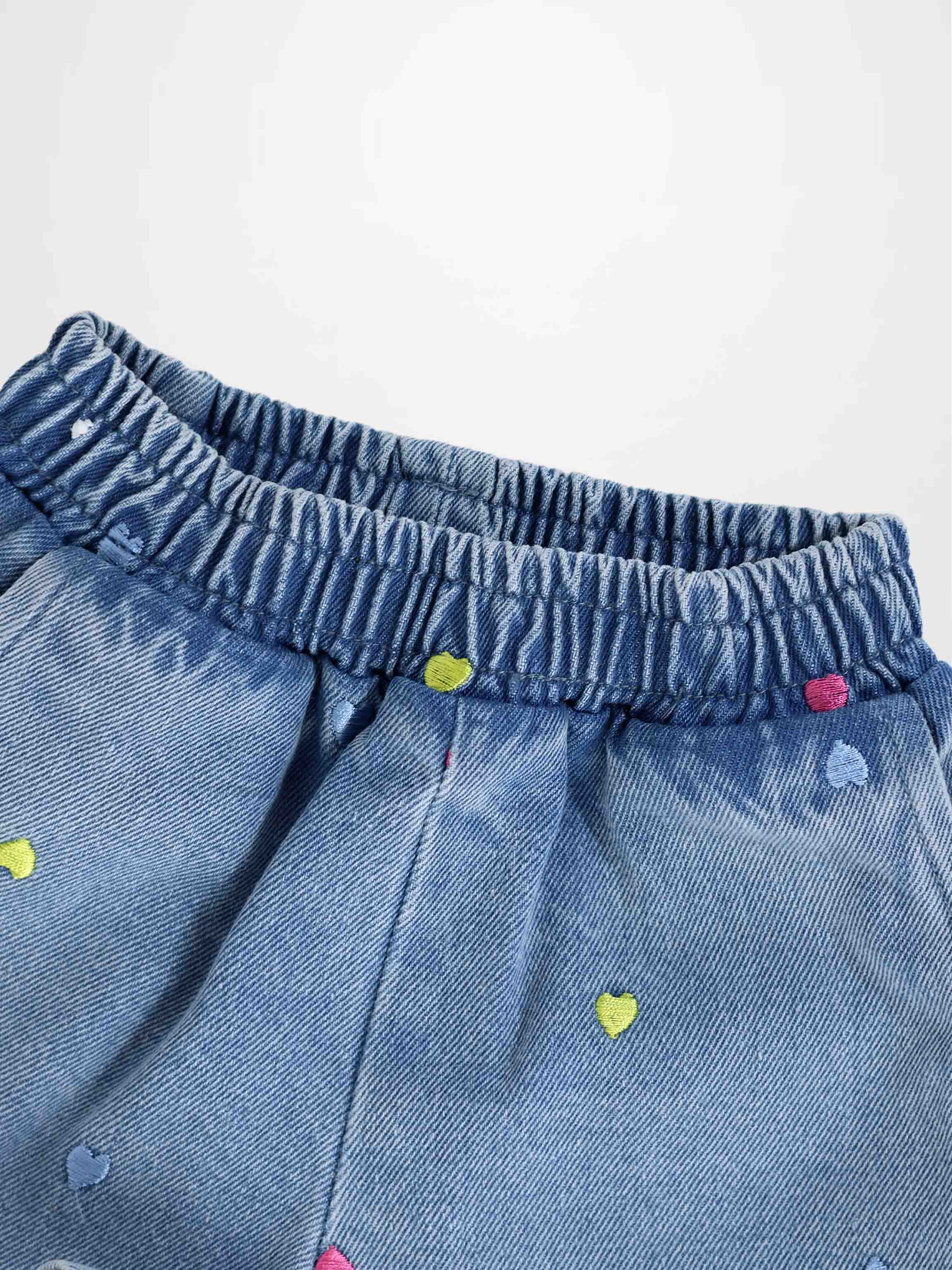 Blue denim shorts with an elastic waistband and colorful embroidered hearts.