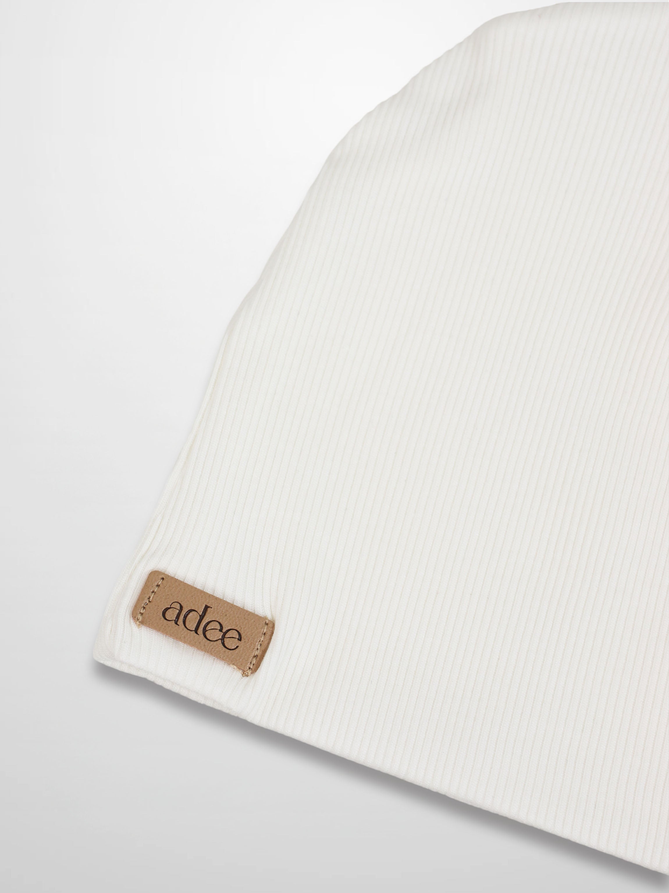 Thin ribbed white beanie by Adee, unisex knit hat with tan brand patch