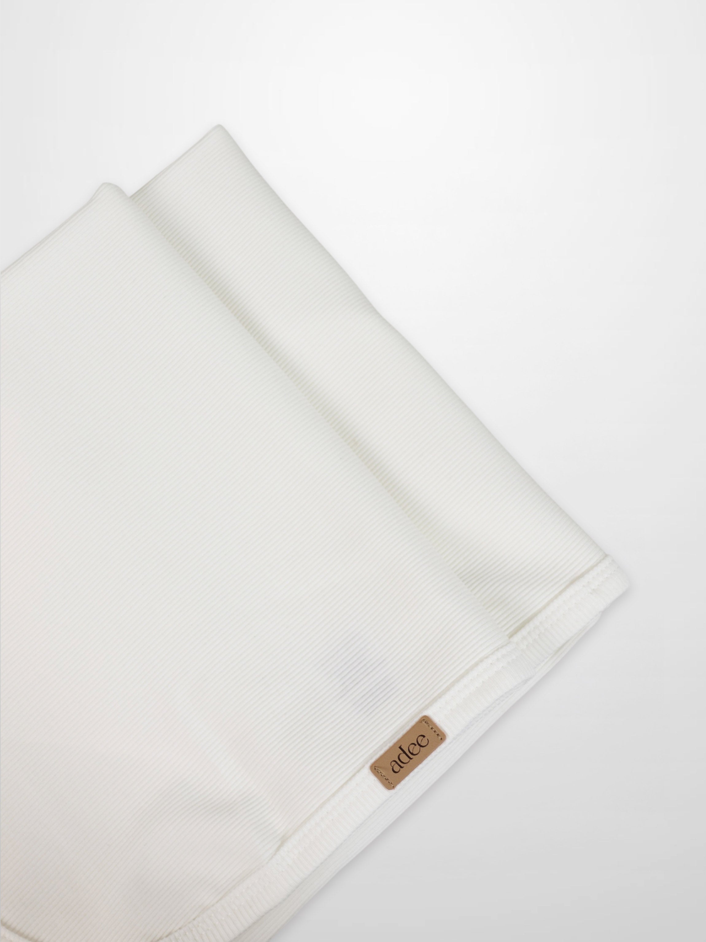 Thin ribbed white blanket by Adee for unisex, lightweight apparel and accessories, with visible brand tag at the edge.