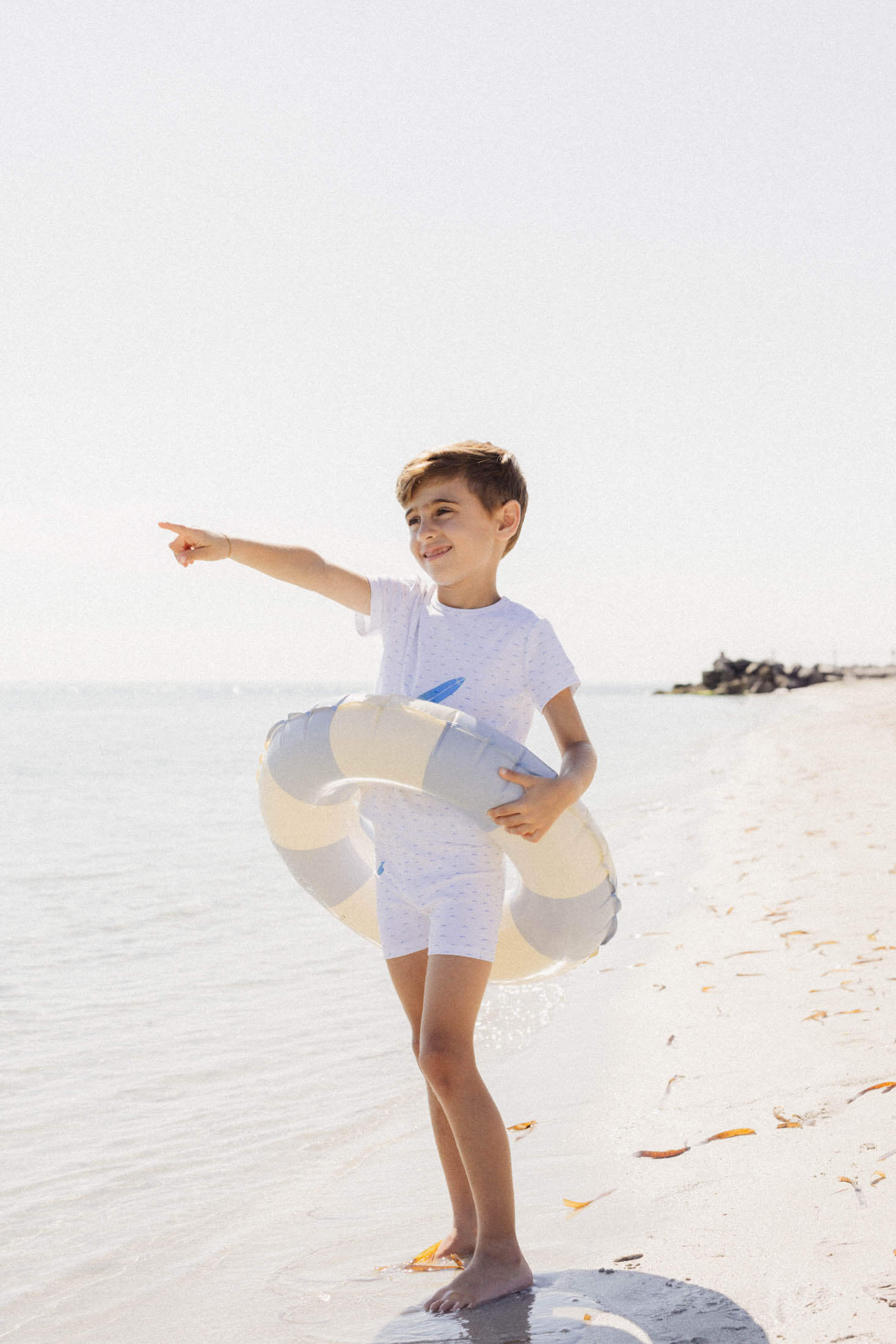Boy in beachwear with float