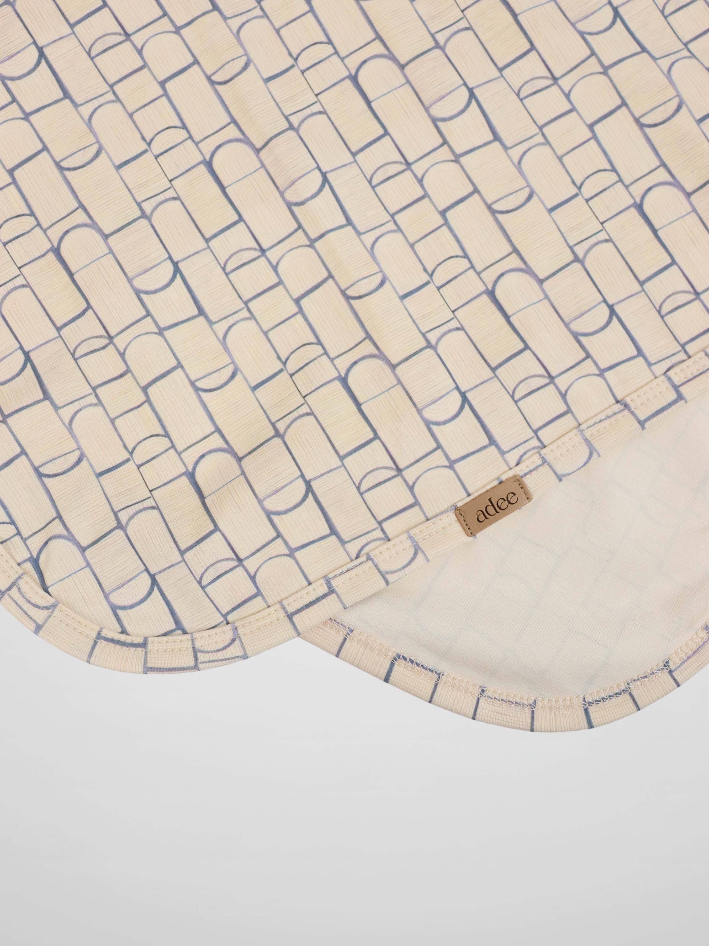 Geometric blanket for boys swaddle with light blue rounded-rectangle pattern on cream fabric; Adee tag visible.