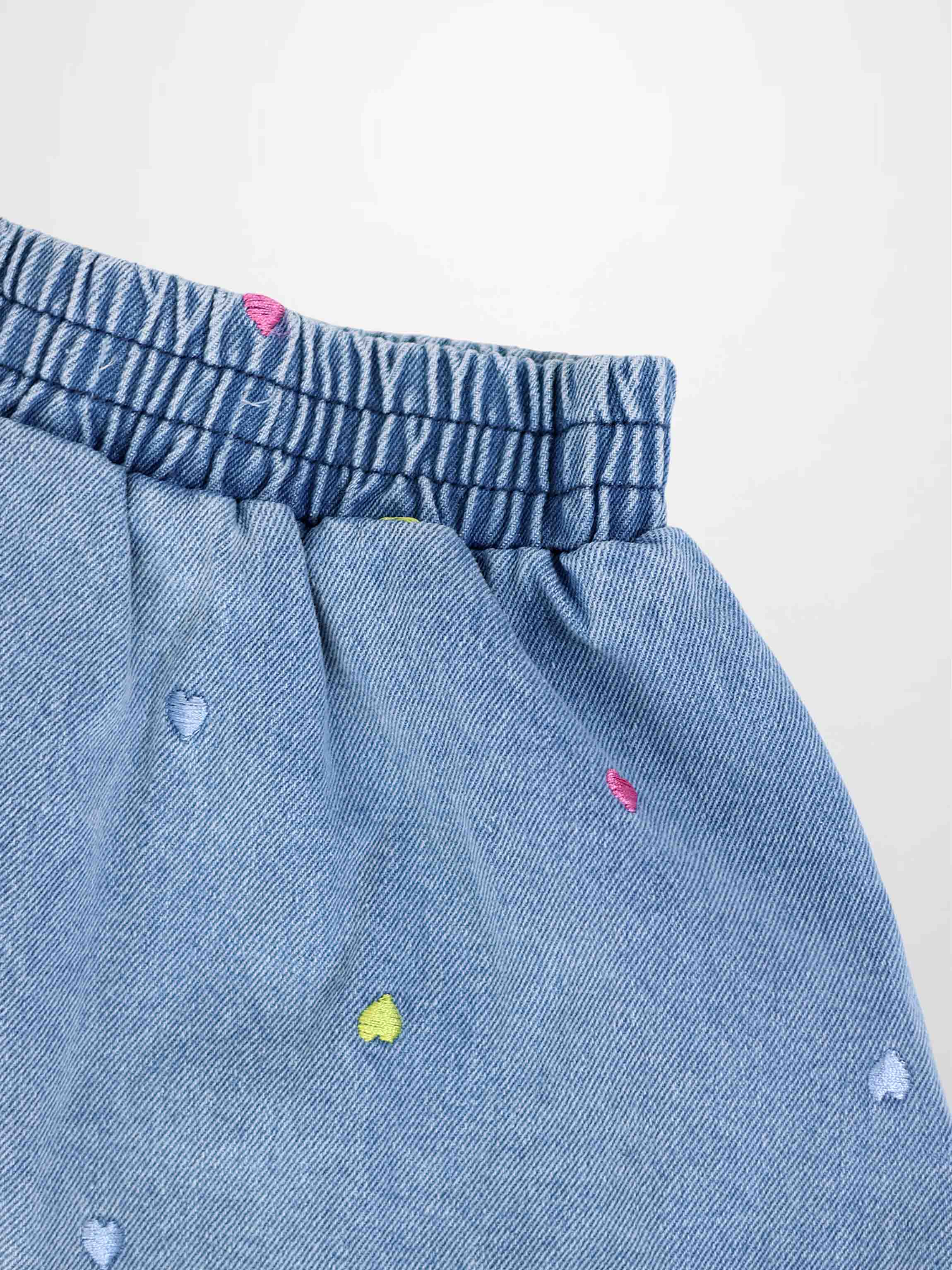 Light blue denim skirt with elastic waistband and multicolor heart embroidery