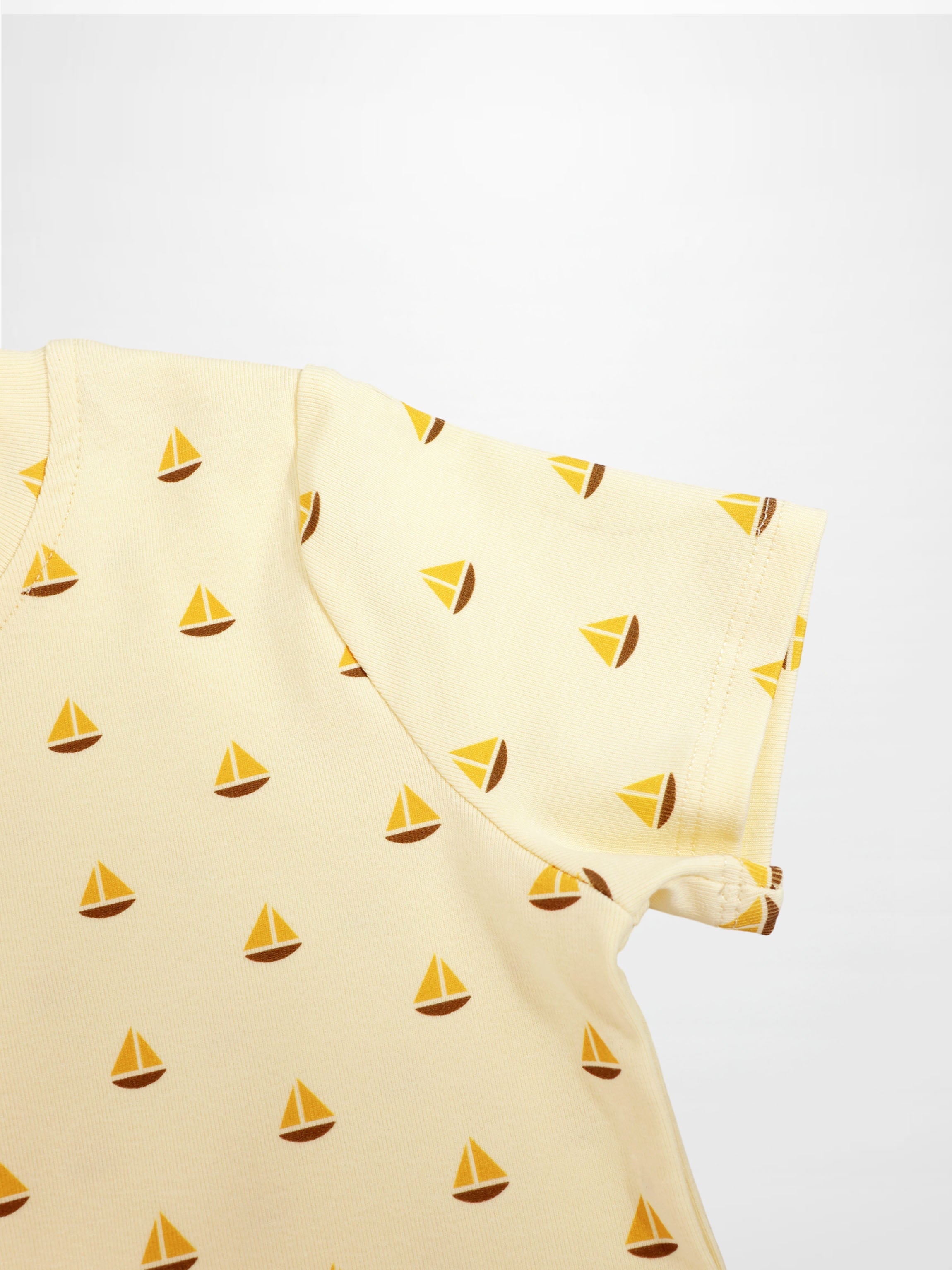 Boat Print T-Shirt with yellow sailboat pattern on cream fabric.