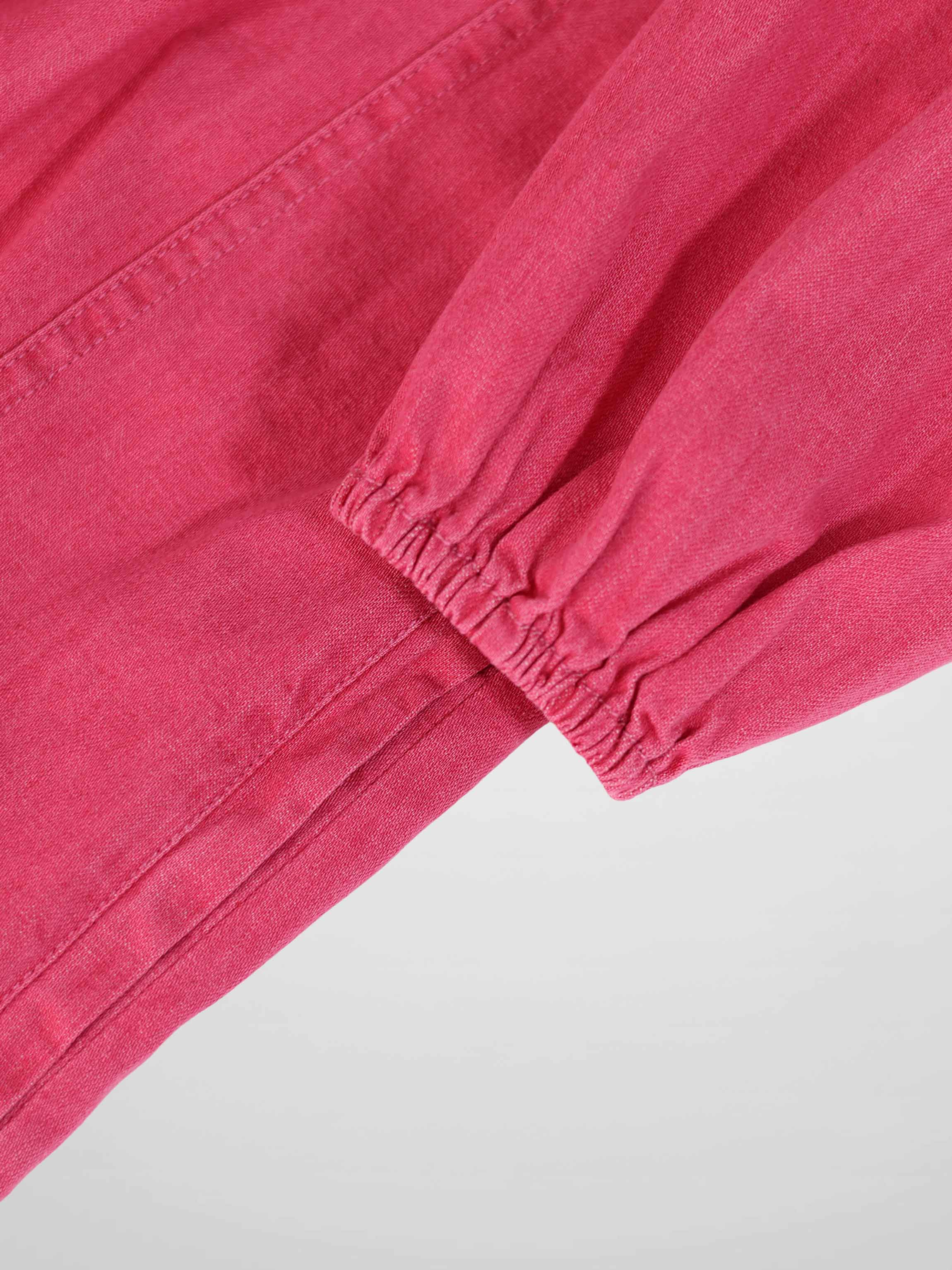 Pink denim 3/4 sleeve dress close-up showing elastic cuff and seam detail.