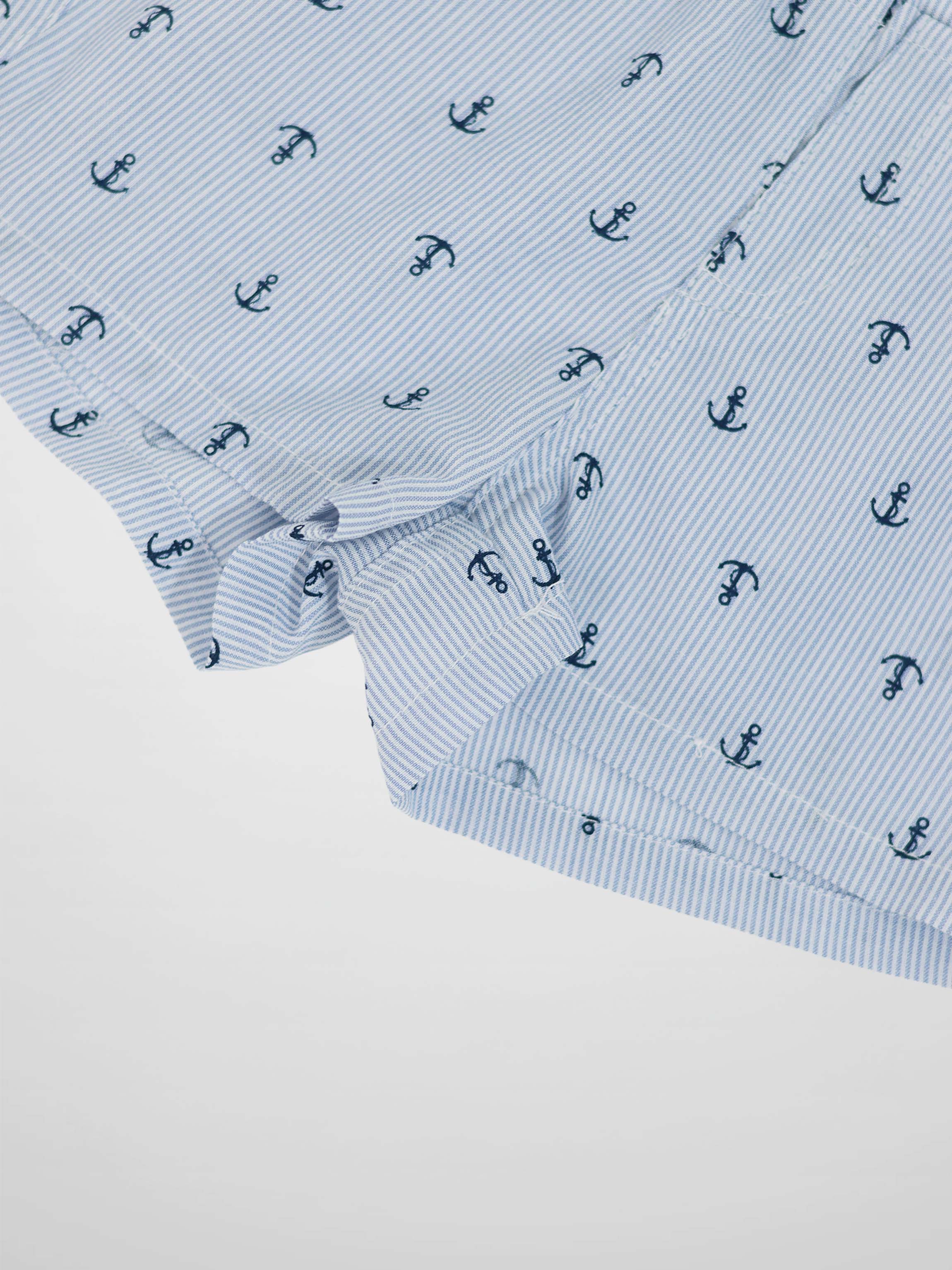 Close-up of light blue diagonal striped fabric with navy anchor pattern.