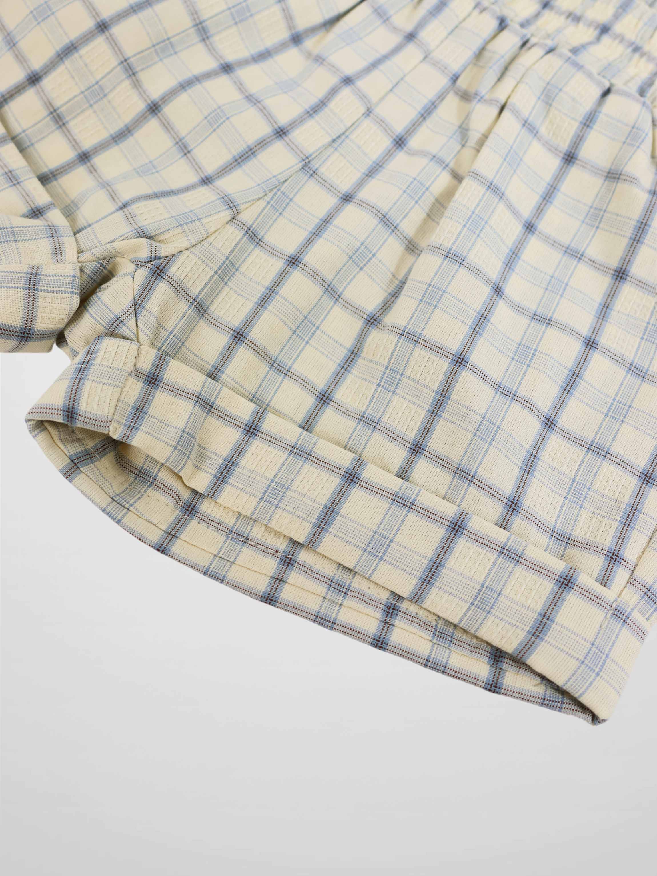 Beige plaid shorts with light blue lines and folded hem detail.