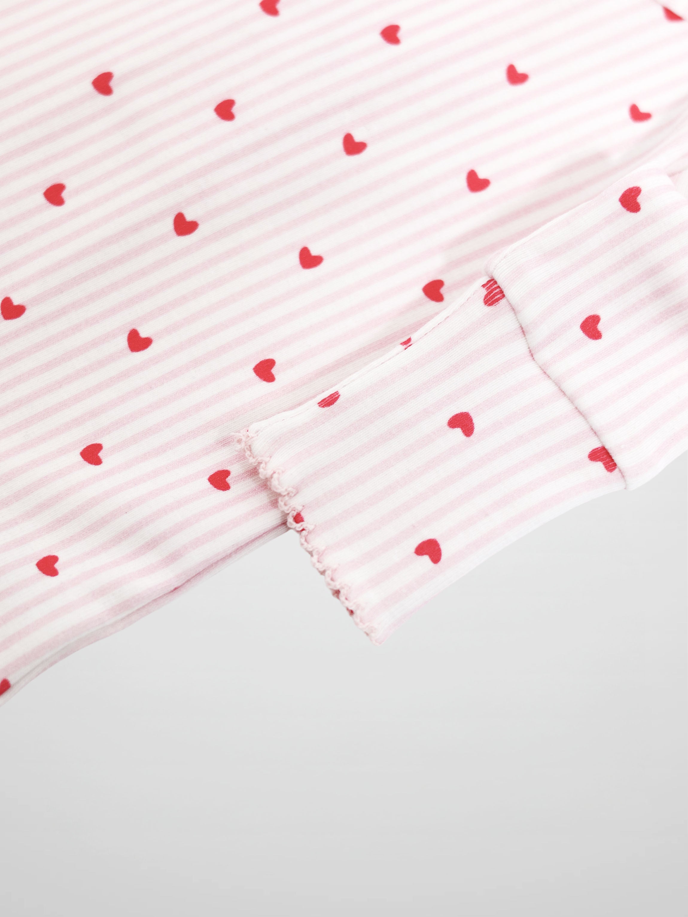 Soft pink and white striped fabric with red hearts and scalloped trim
