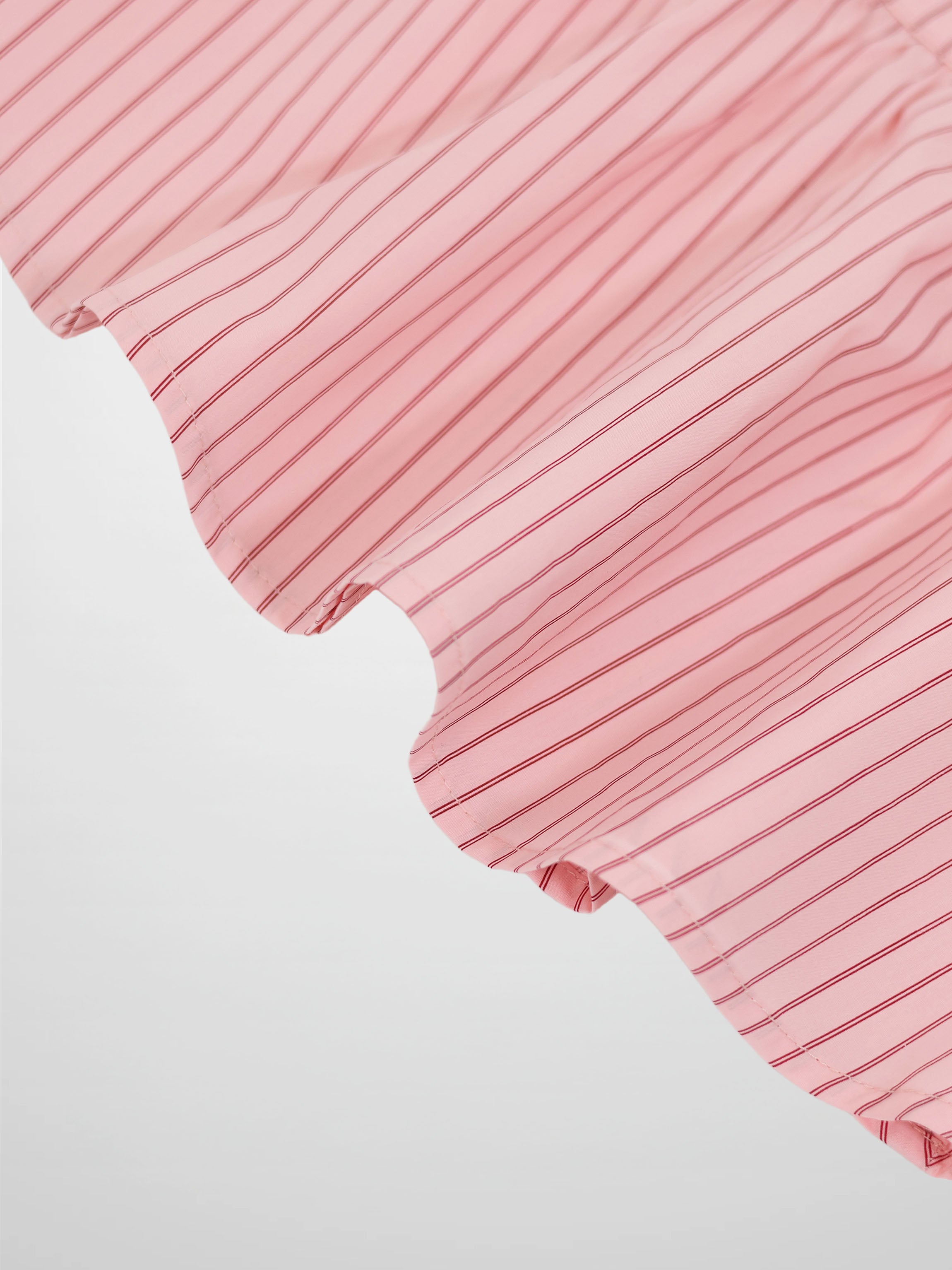 Pink striped cotton skirt with curved hem detail.