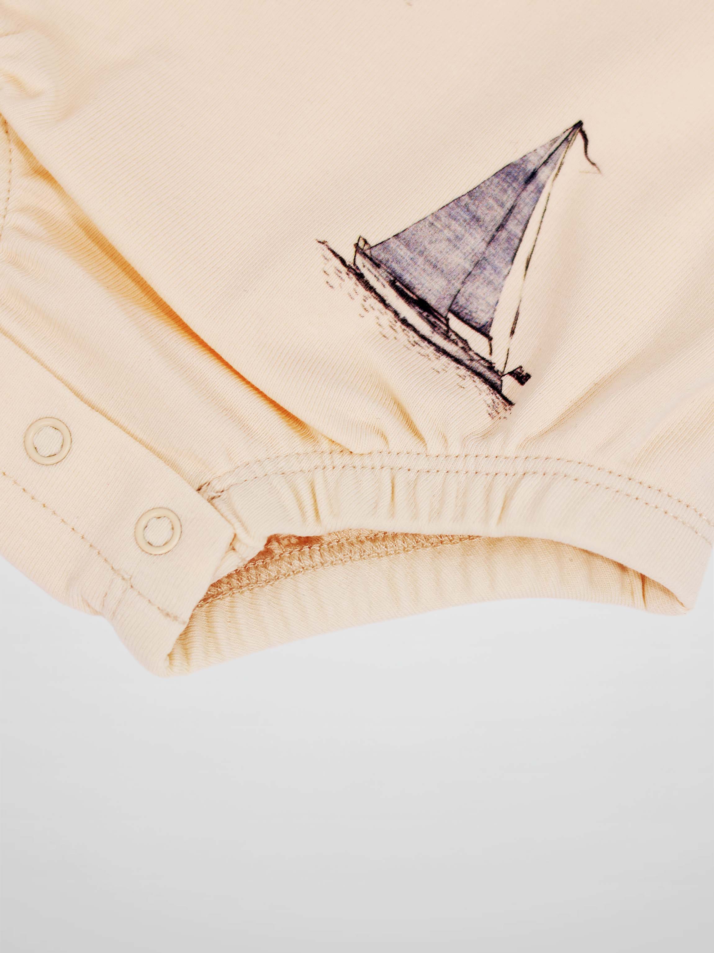 Sail Boat Romper for boys in peach with a sailboat graphic and snap closures.