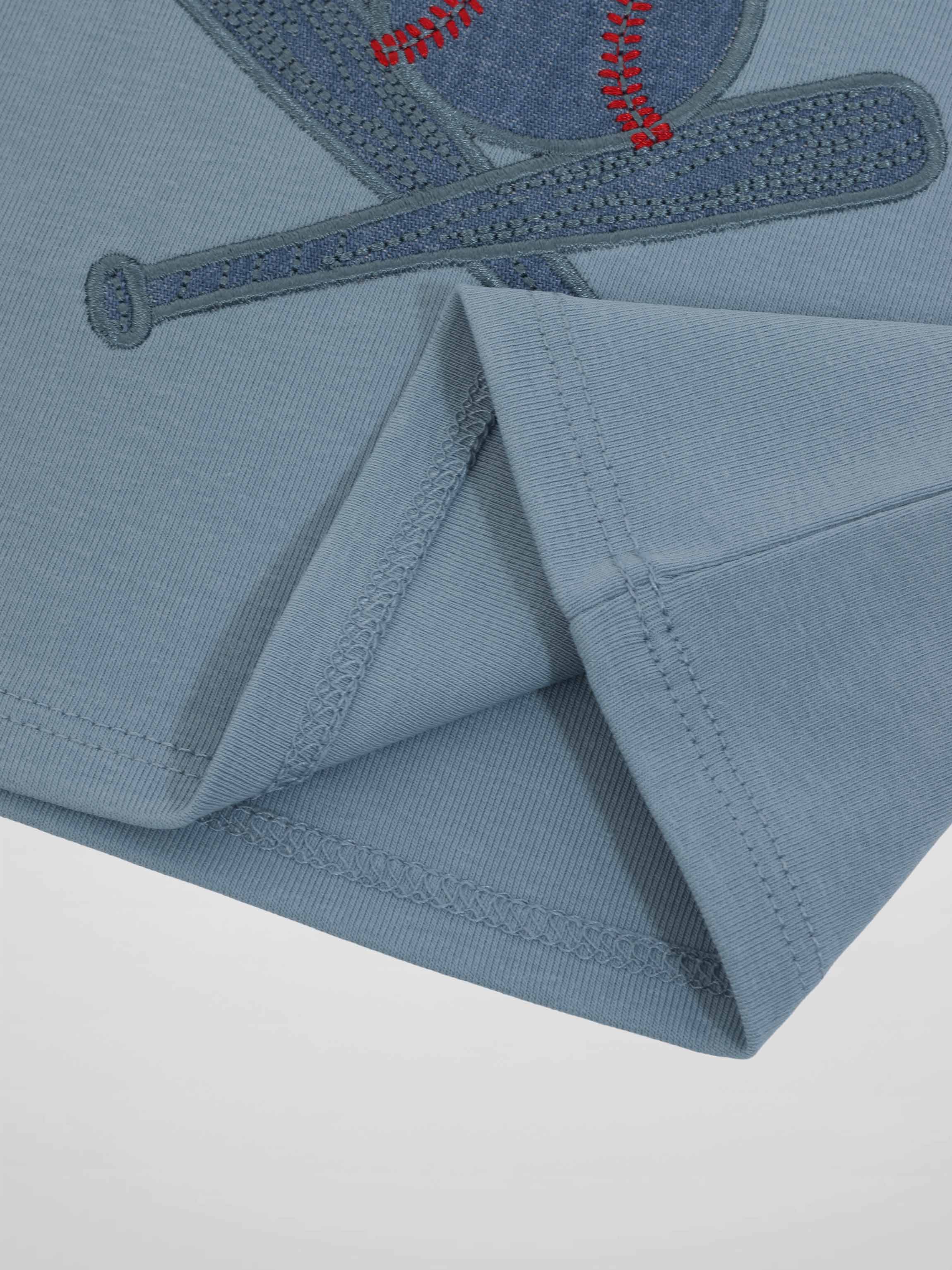 Blue baseball T-shirt with embroidered baseball and bat motif, close-up seam detail.