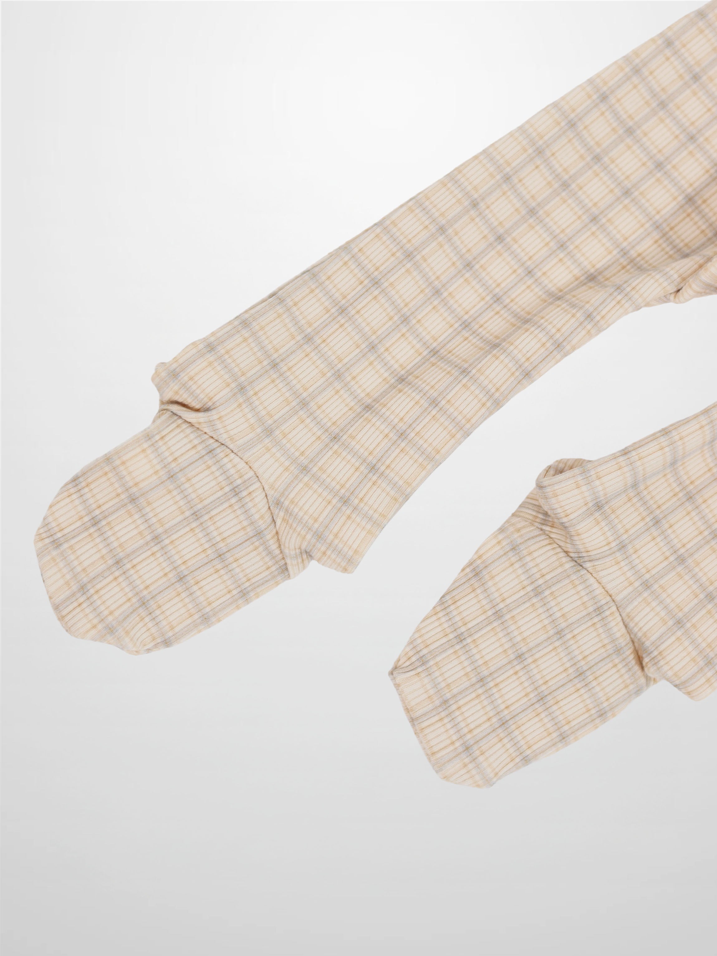 Beige oatmeal grid plaid fabric on baby romper sleeves with light blue and brown lines.