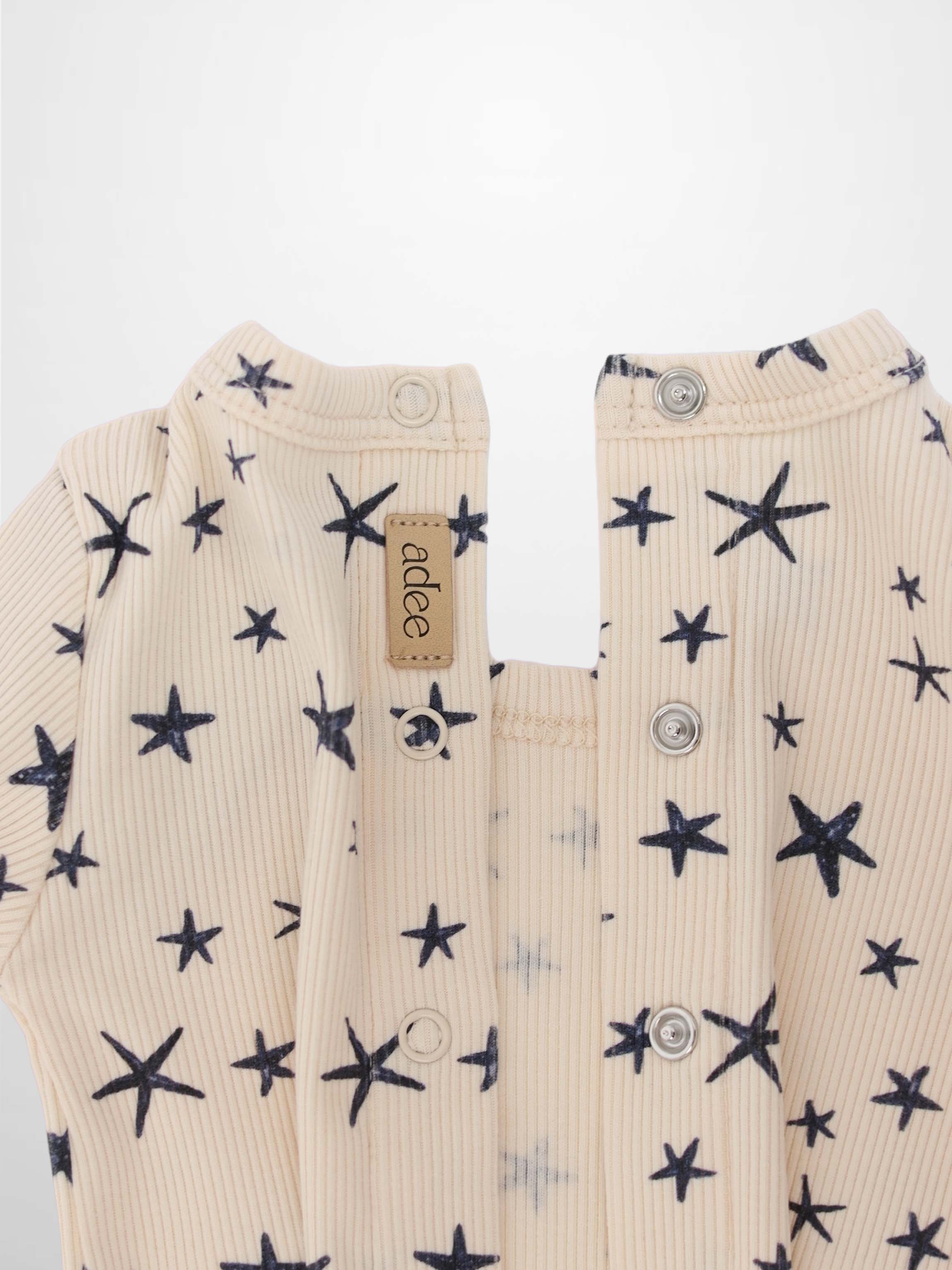 Star Stretchy boys stretchies by Adee in light beige ribbed fabric with navy star pattern; front snaps.