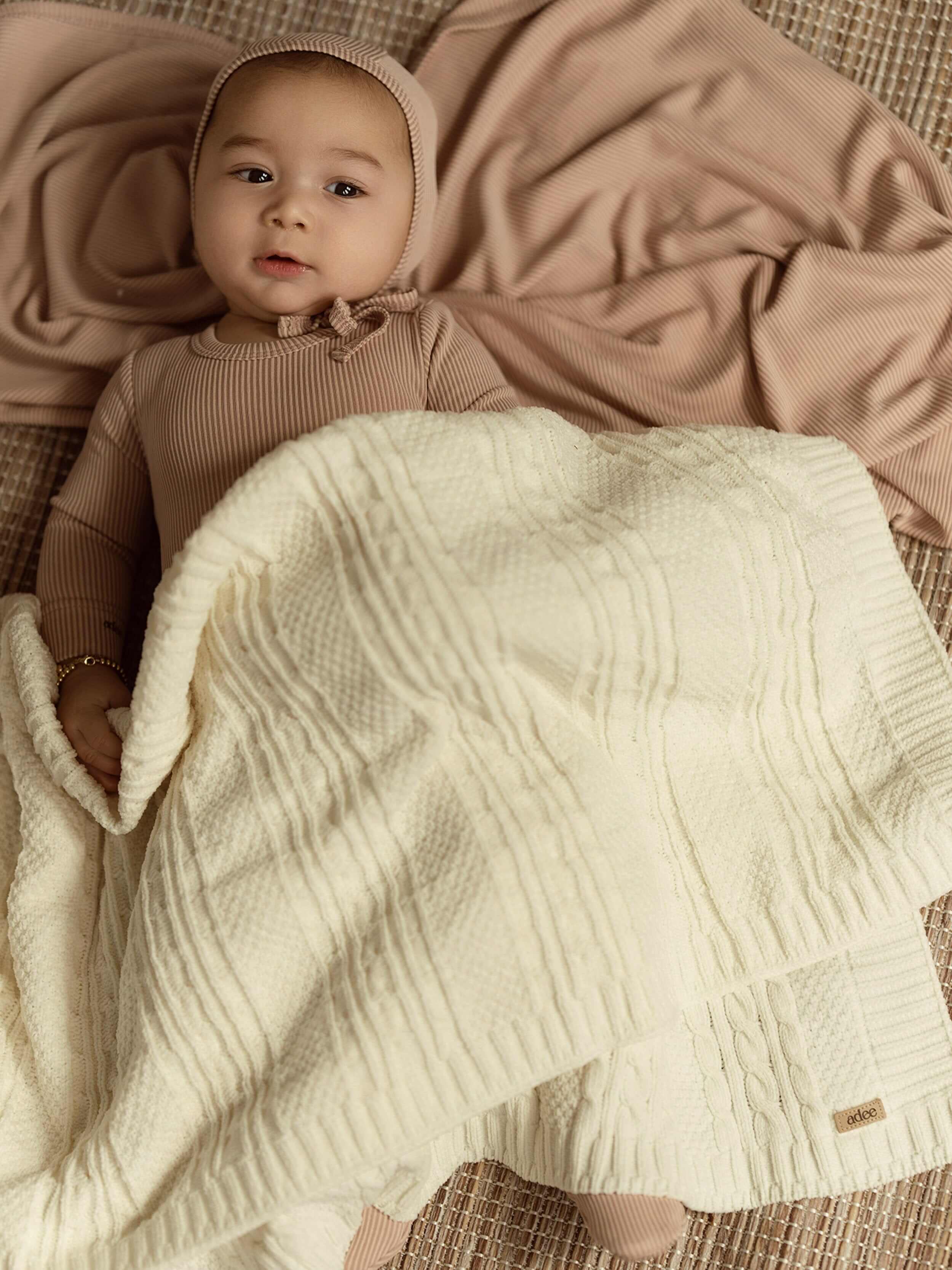 cream or white knit baby blanket stylish and warm on a cute baby
