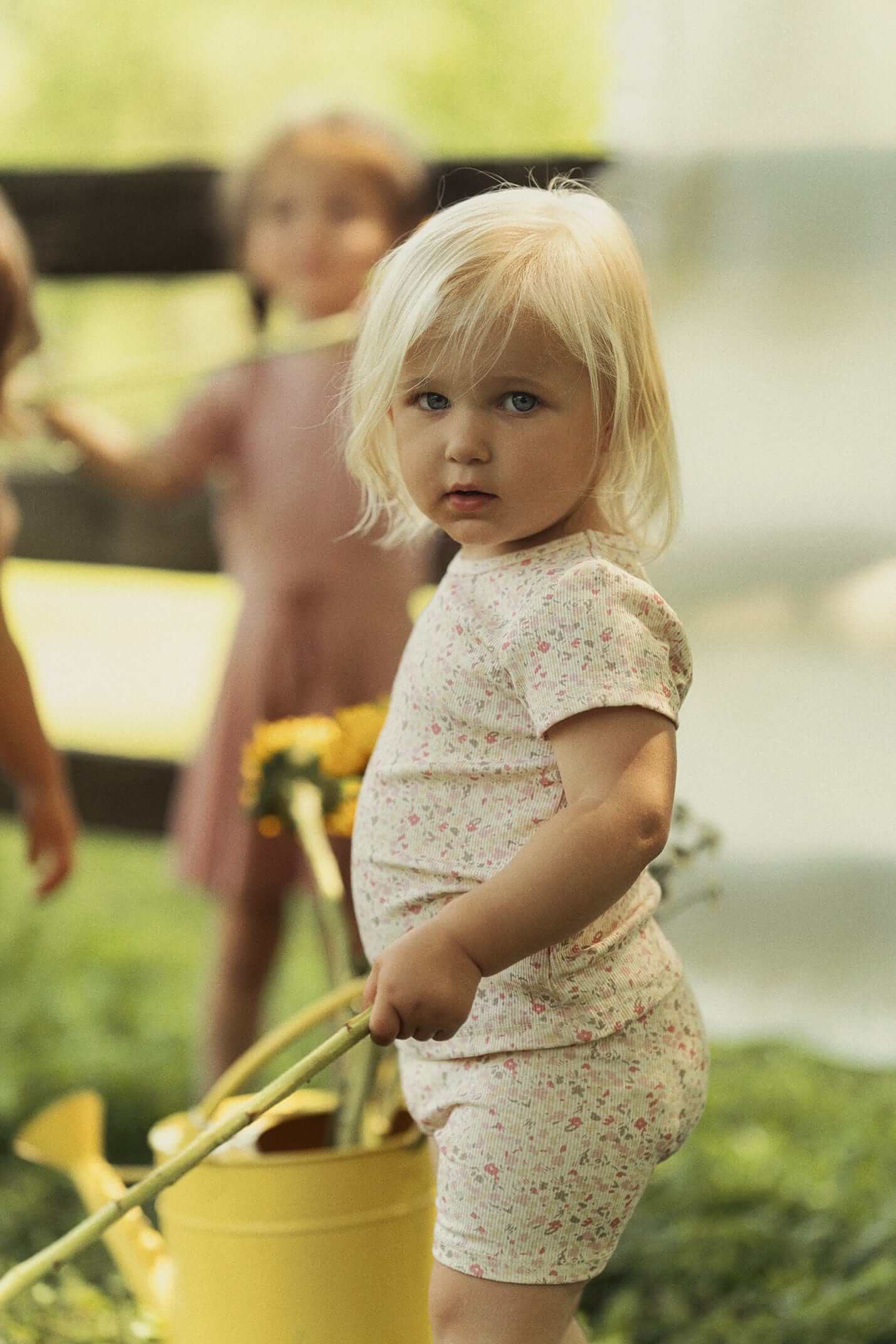 Water Color Short Set-Pink for little girls by Adee, pink floral print two-piece shorts set worn by a child outdoors.