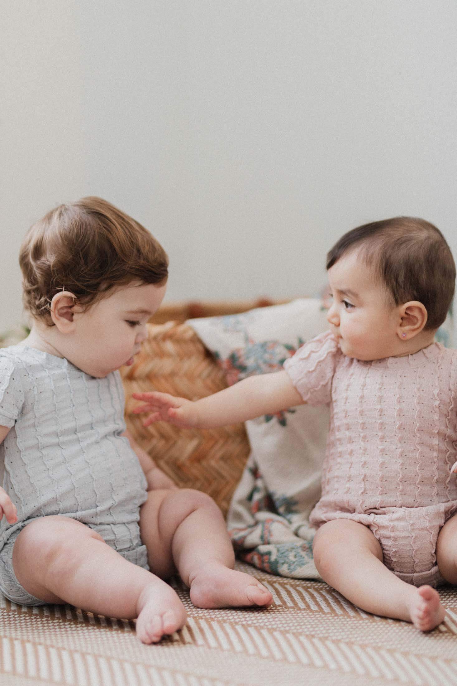 Babies wearing ruffled pointelle rompers