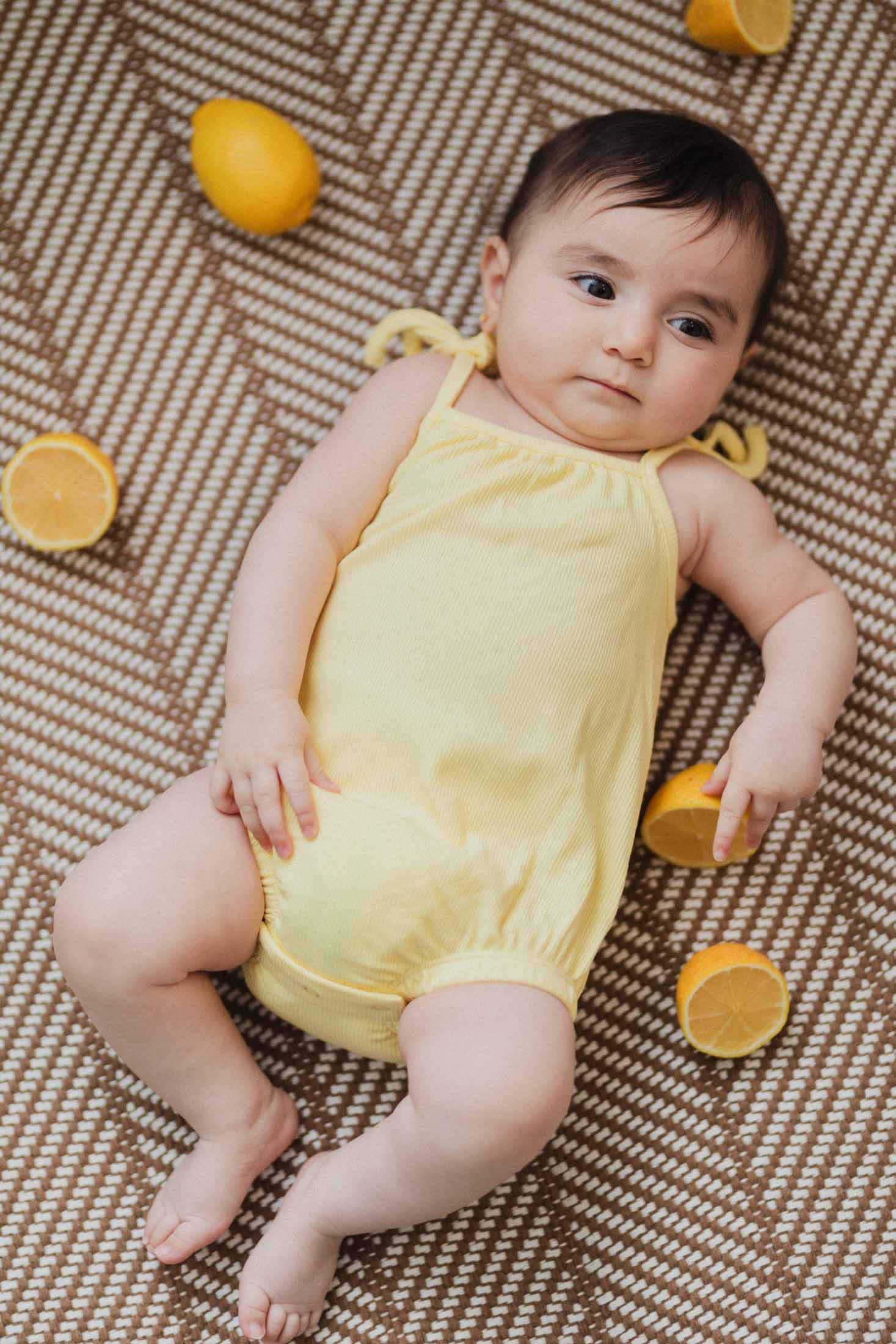 Baby girl in yellow romper.