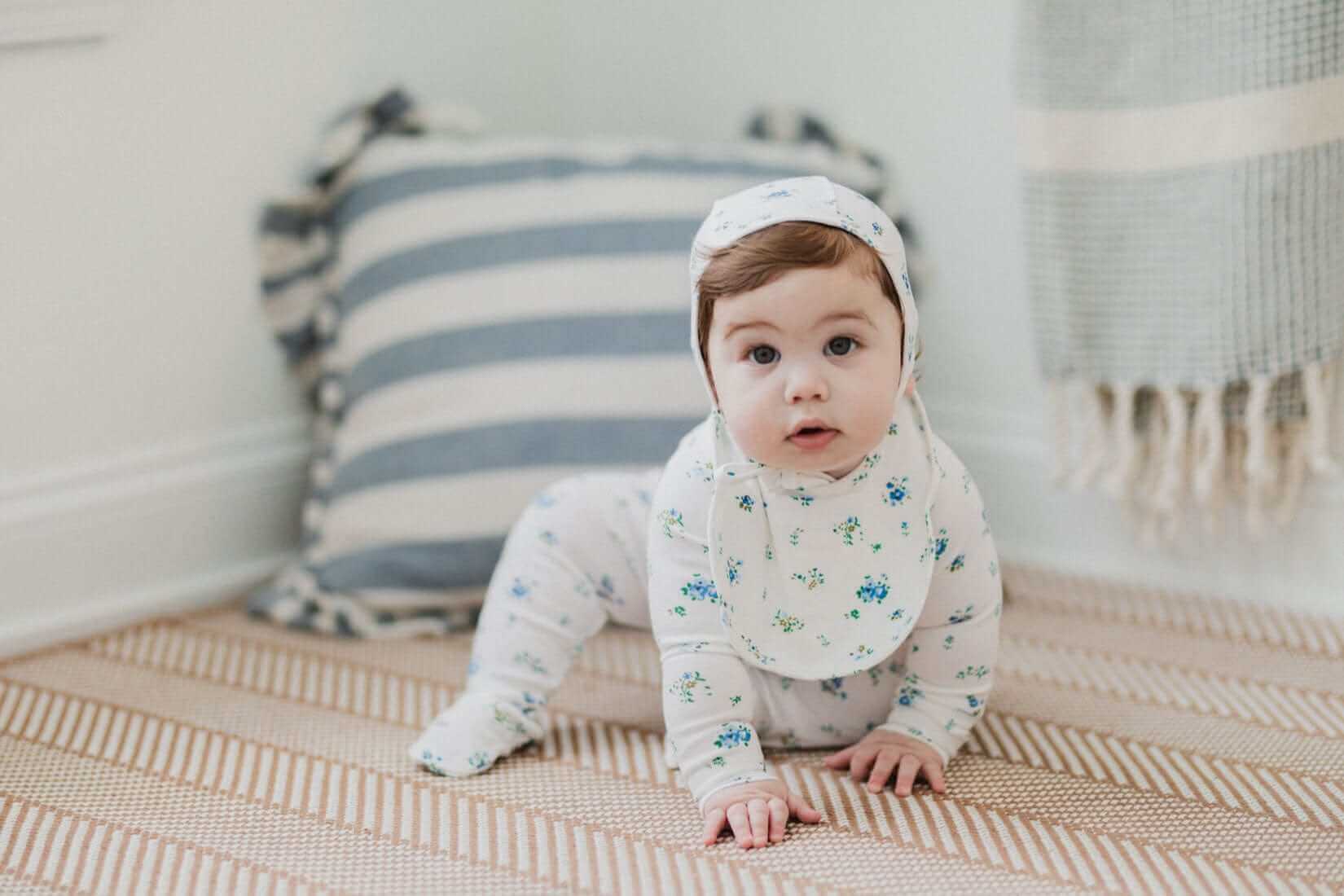 Baby boy in floral jumpsuit, bonnet, bib