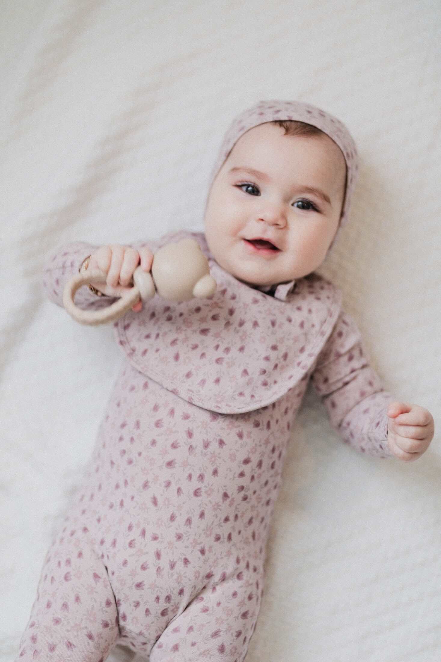 Baby girl in pink tulip jumpsuit bonnet, and bib