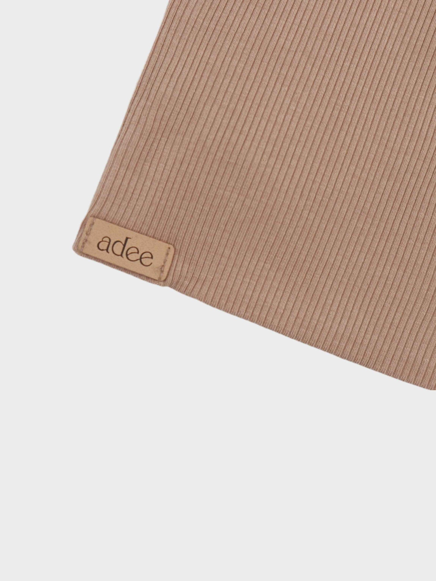 Thin ribbed beige baby hat.