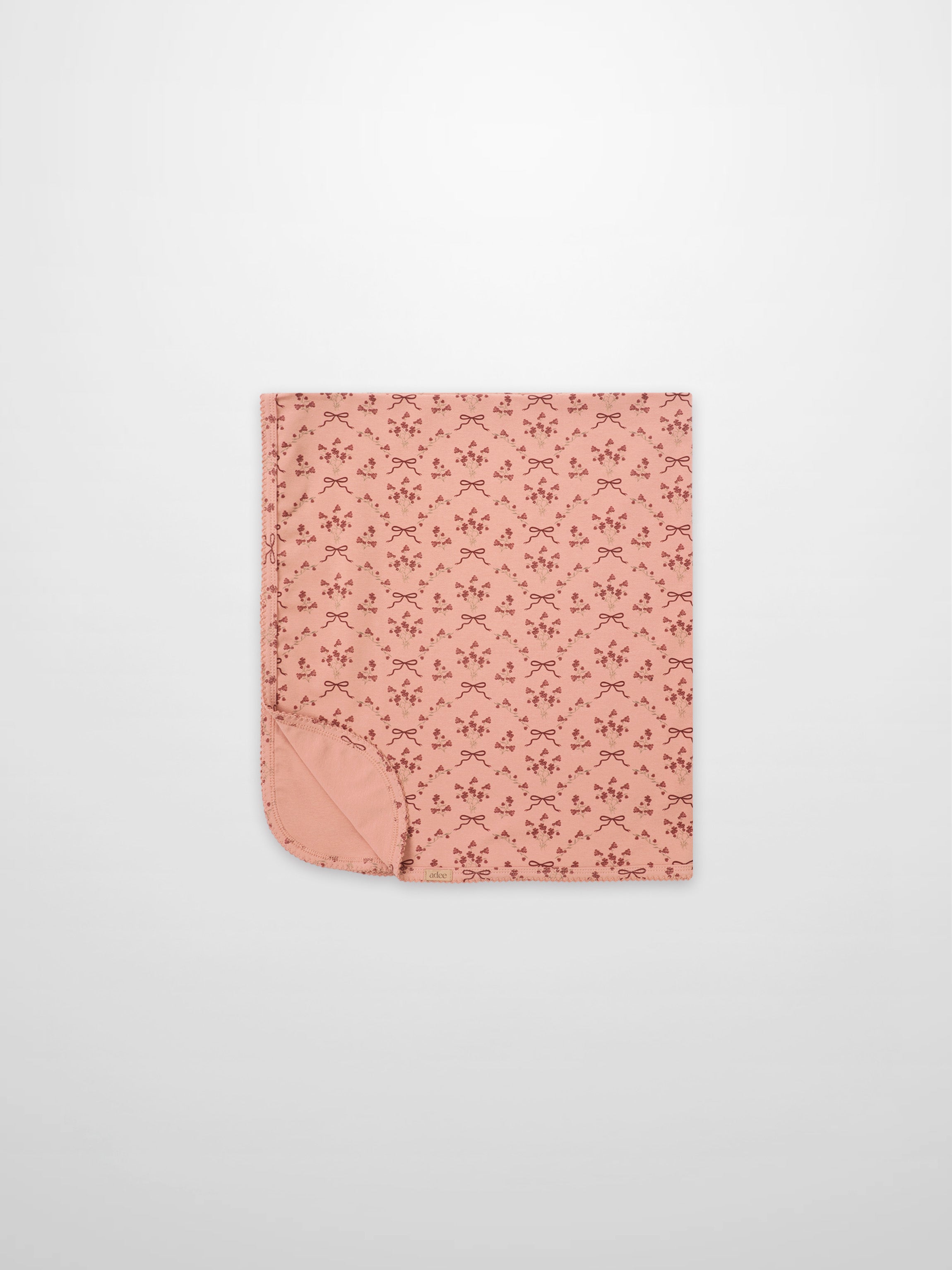 Adee Bow Bouquet Blanket for girls; pink swaddle blanket with small floral bouquets and bow motifs.