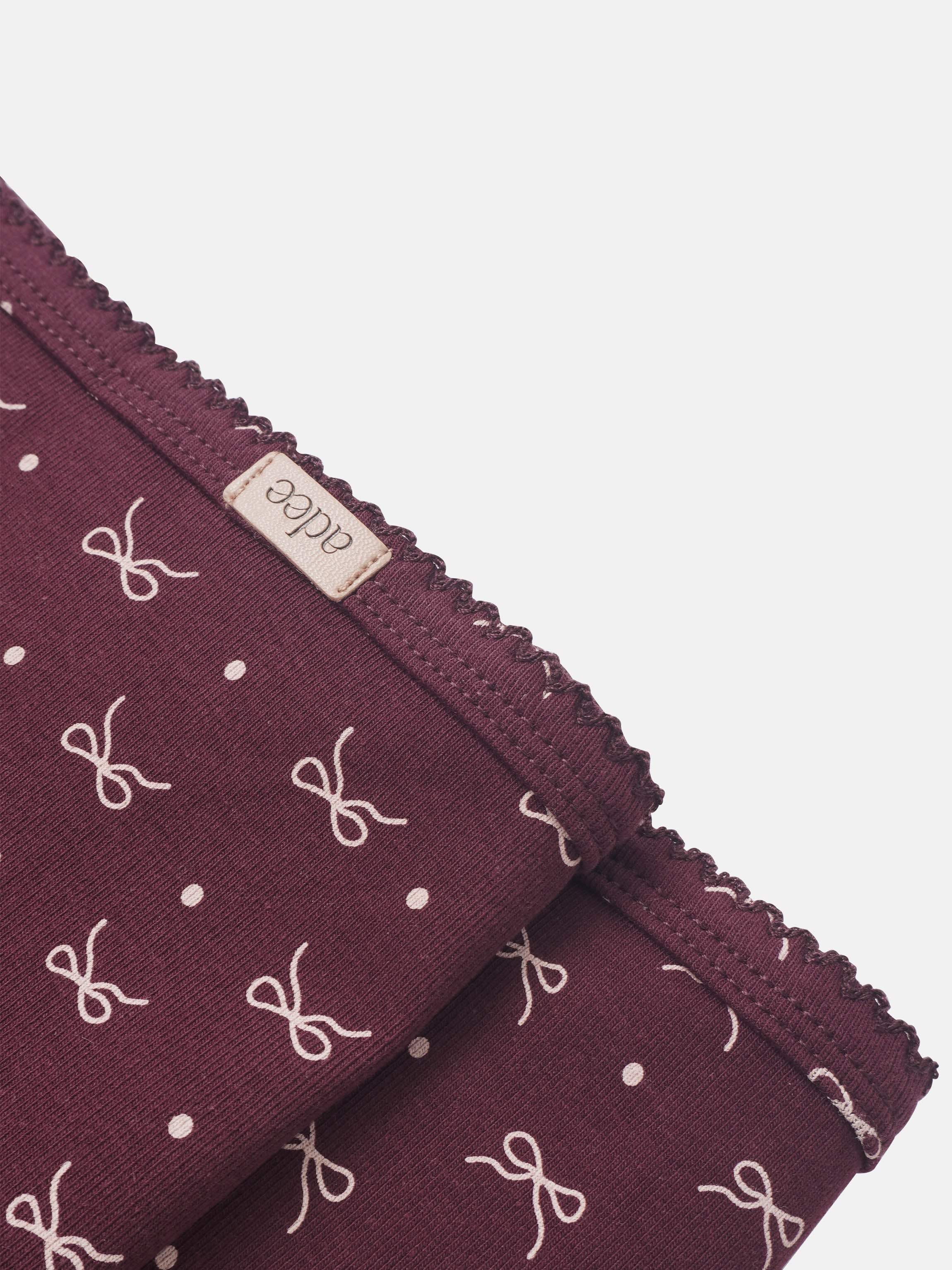 Burgundy bow blanket for girls swaddle with white bows and polka dots, Adee brand, scalloped edge