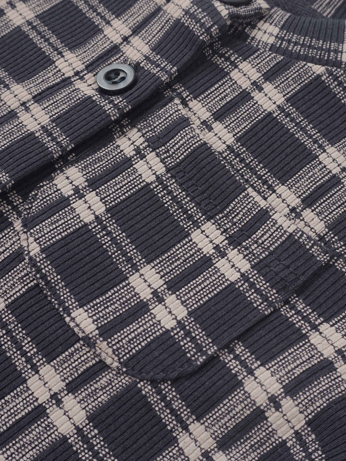 Plaid blue boys pajamas fabric close-up with a visible button