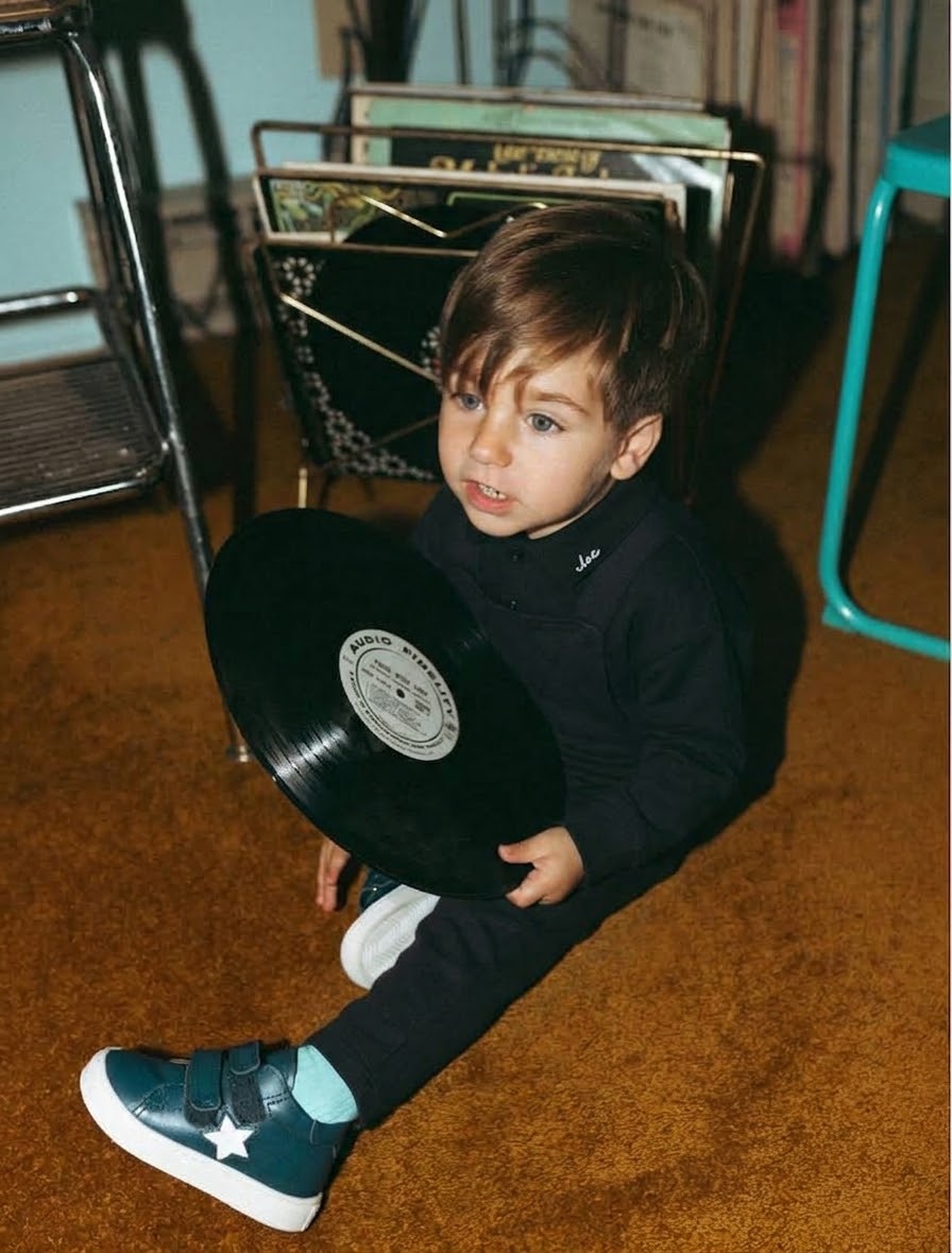 Denim Overalls - Black, unisex apparel; child seated on a brown carpet holding a vinyl record.