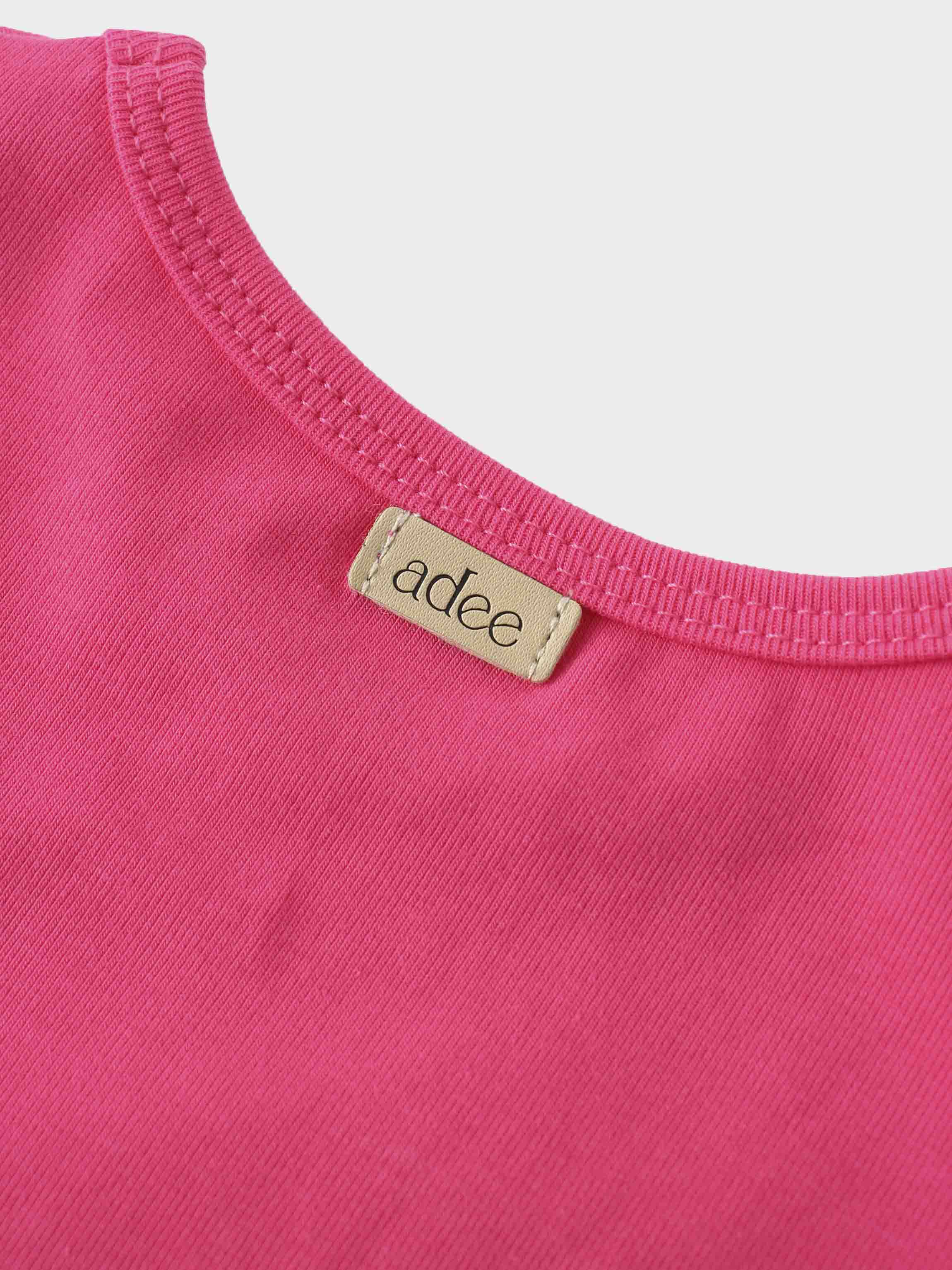 Close-up of pink shirt collar for girls, featuring label.
