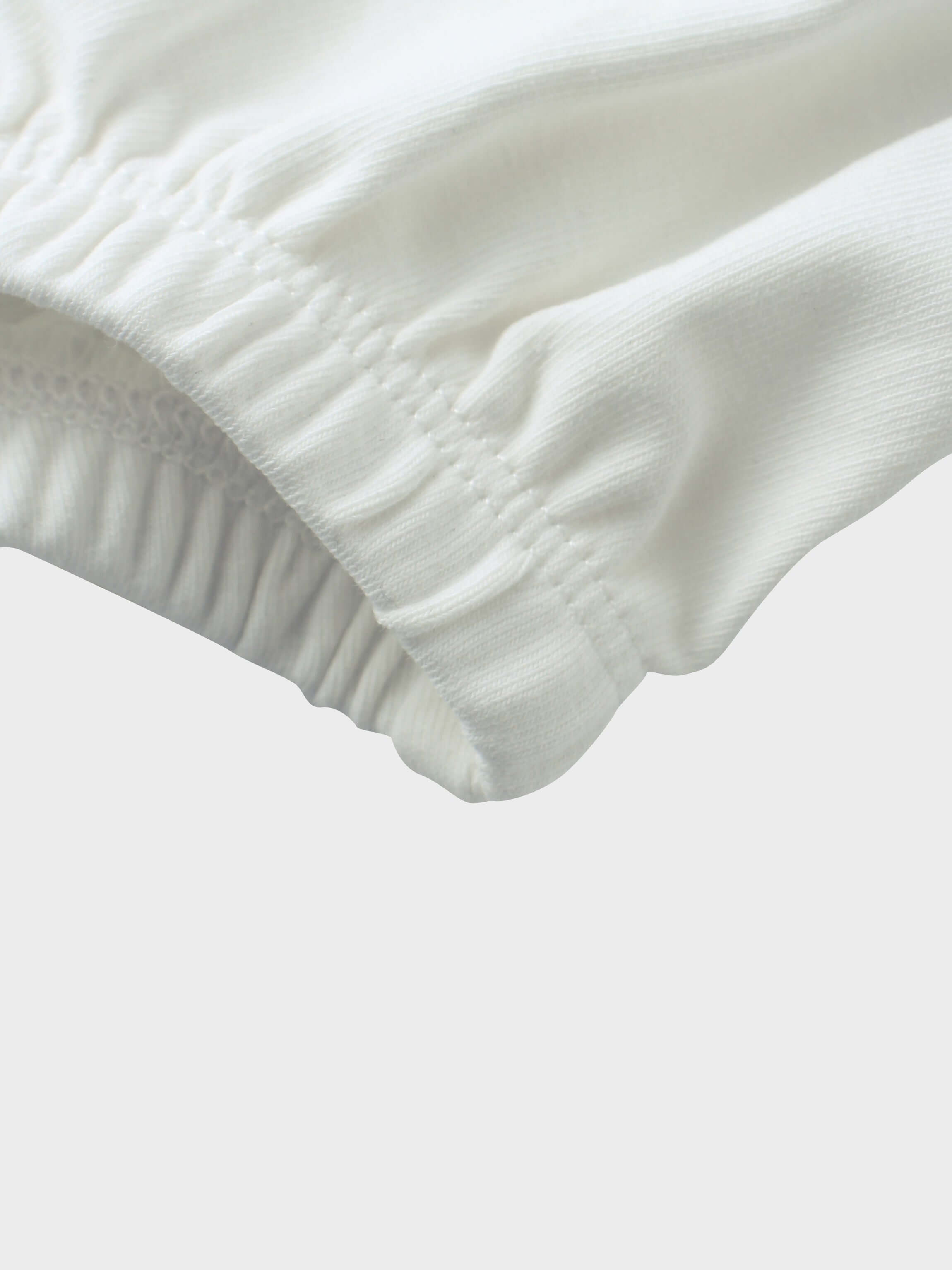 Soft white baby romper leg detail