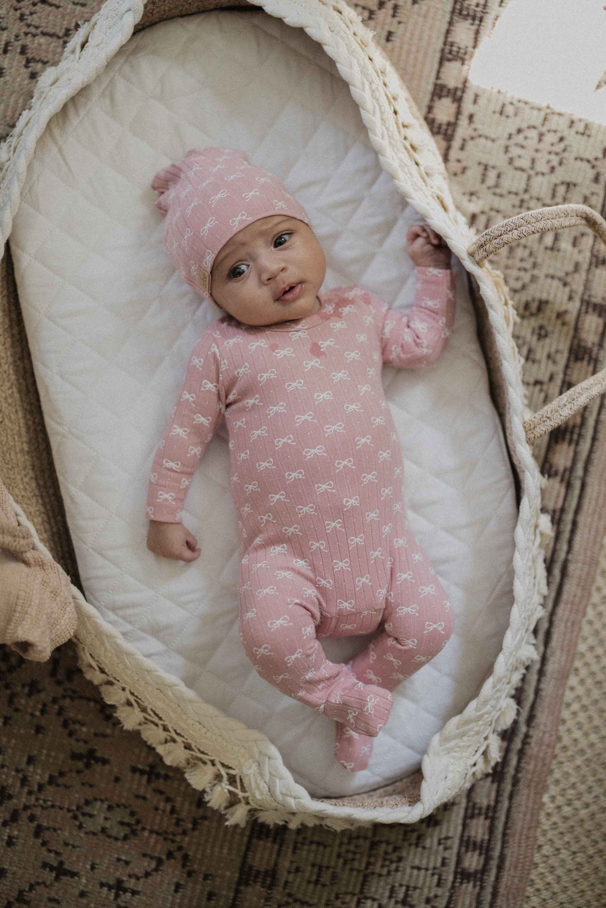 Baby in soft pink jumpsuit hat