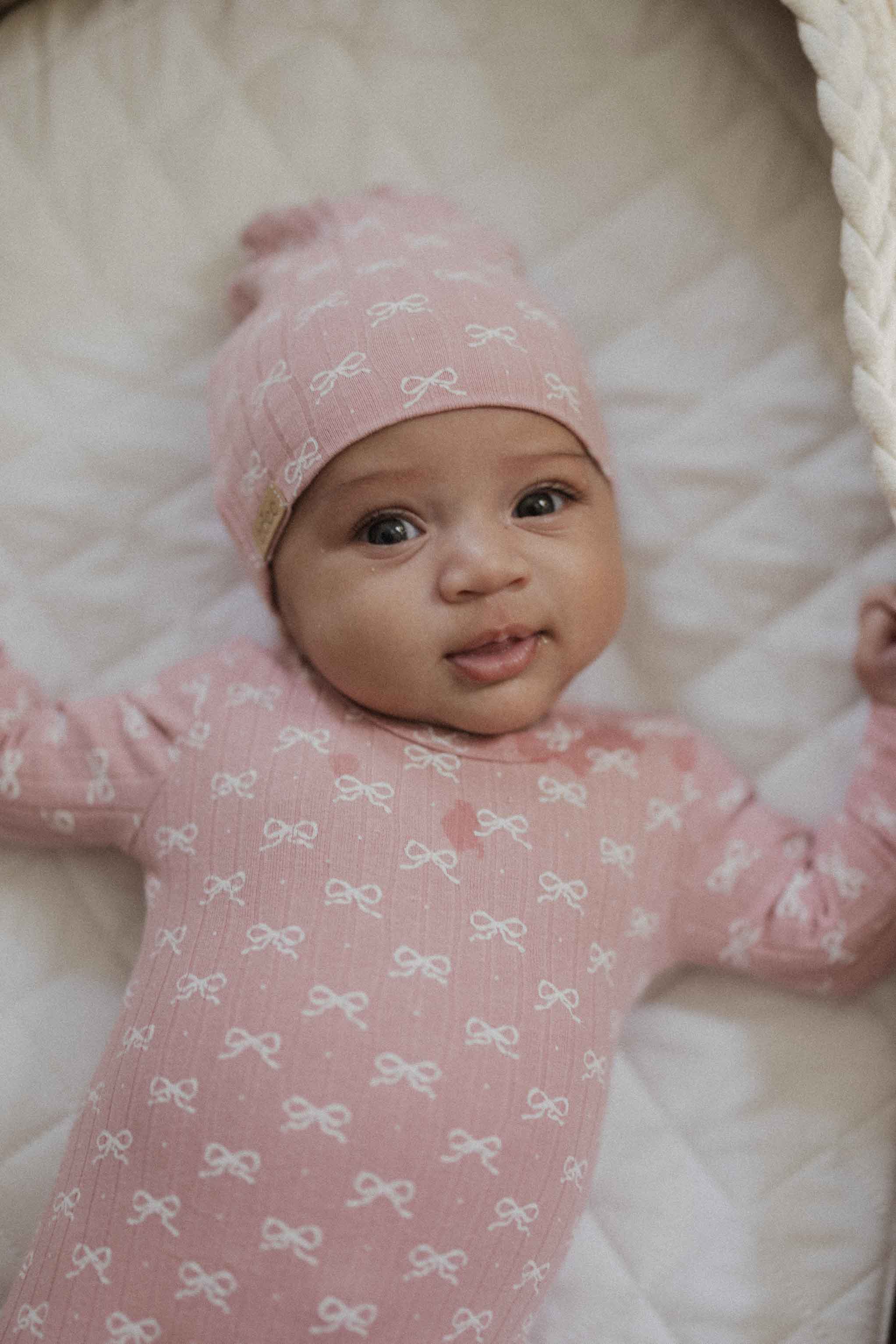 Baby in soft pink jumpsuit hat