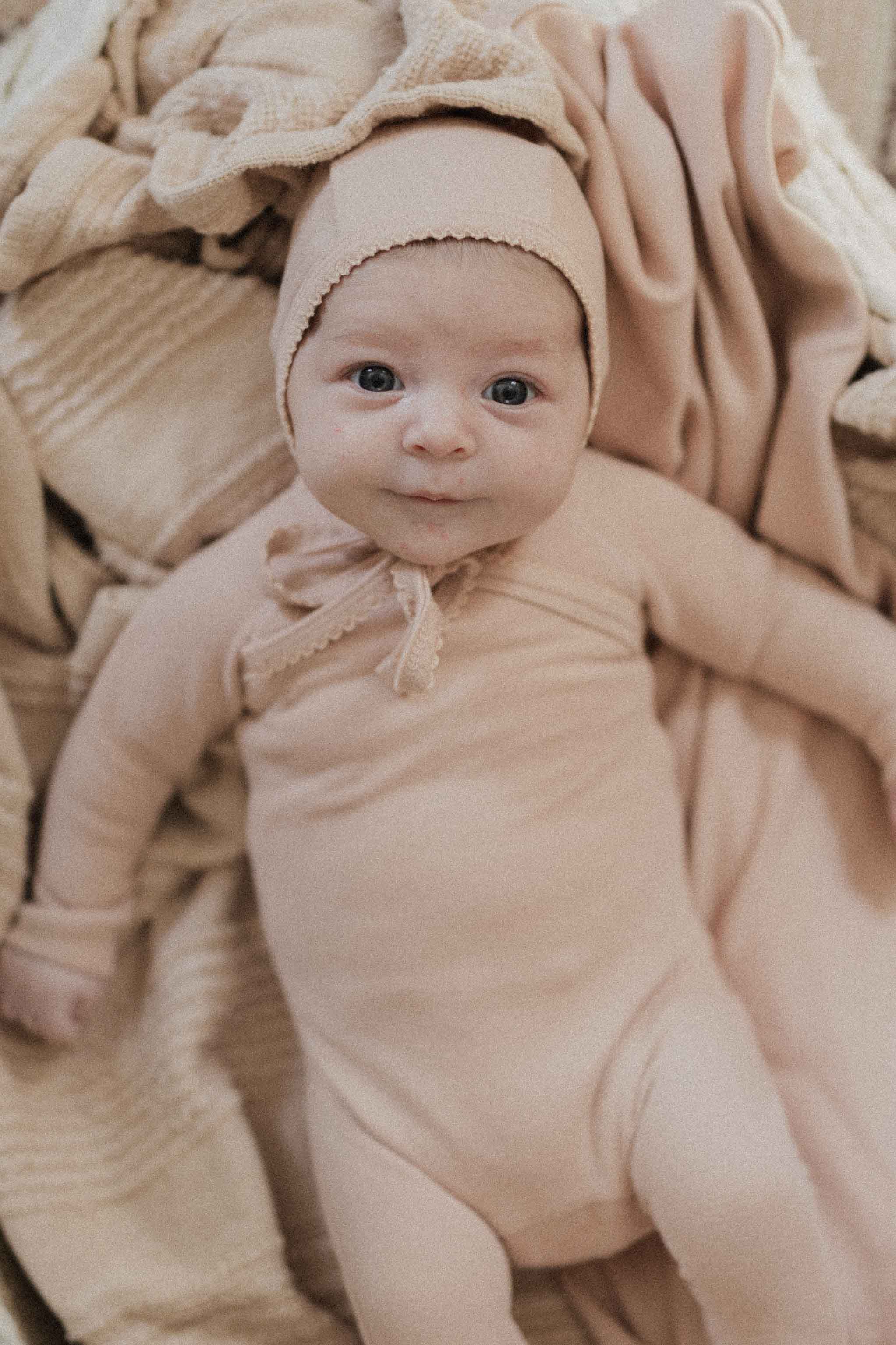 Crossover Twill Stretchy & Bonnet taupe unisex baby set; baby wearing matching bonnet and onesie.