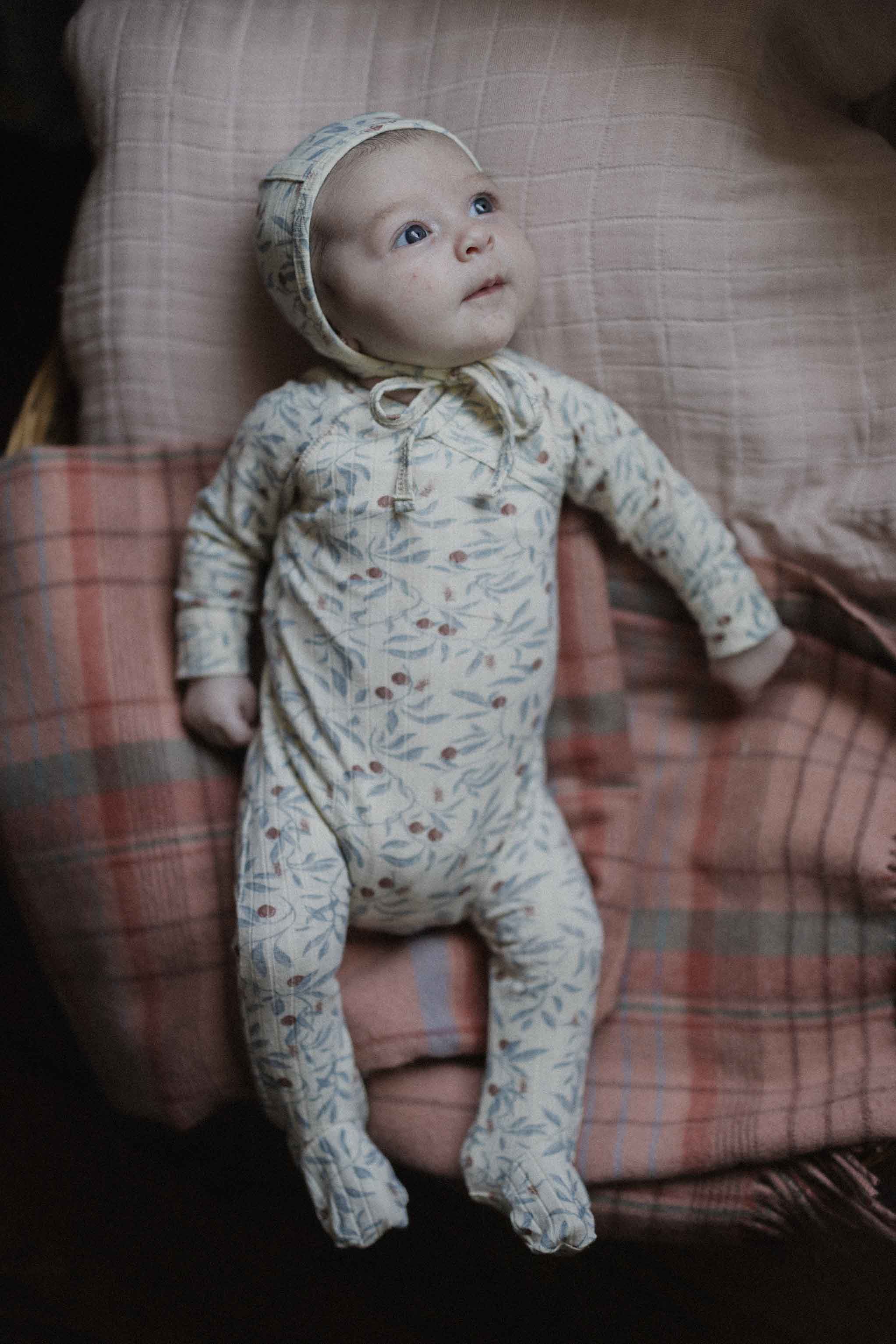 Adee Olive Branch Stretchies footed baby jumpsuit with bonnet; cream fabric with blue olive leaf print