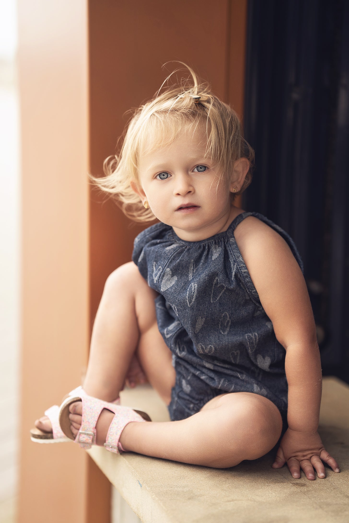 Denim Heart Romper for girls, blue denim with a white heart pattern, worn by a toddler.