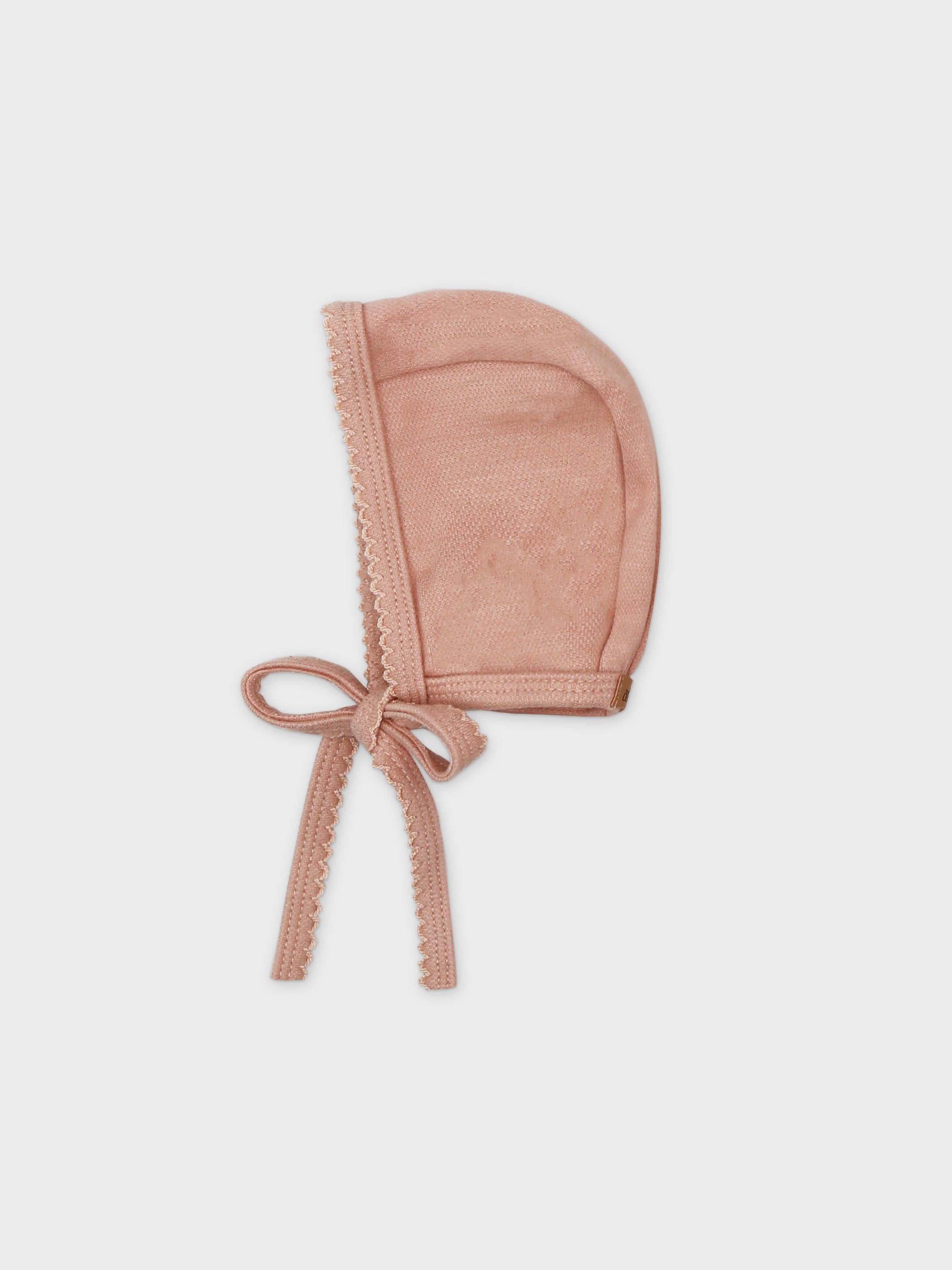 Pink bonnet for girls with tied ribbons and scalloped trim on stretchy twill fabric