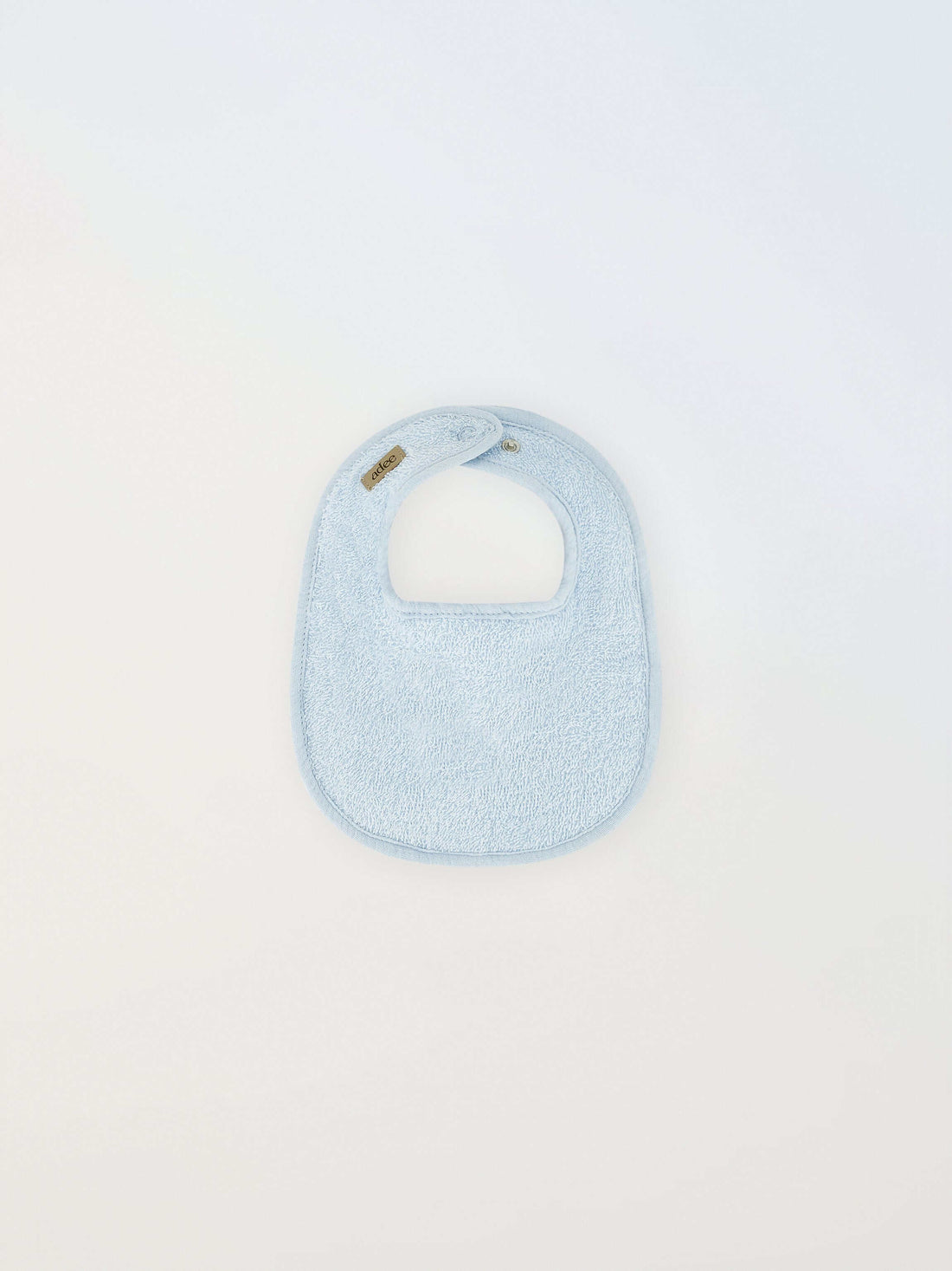 Small blue Adee bib for boys in terry cloth with brand tag visible