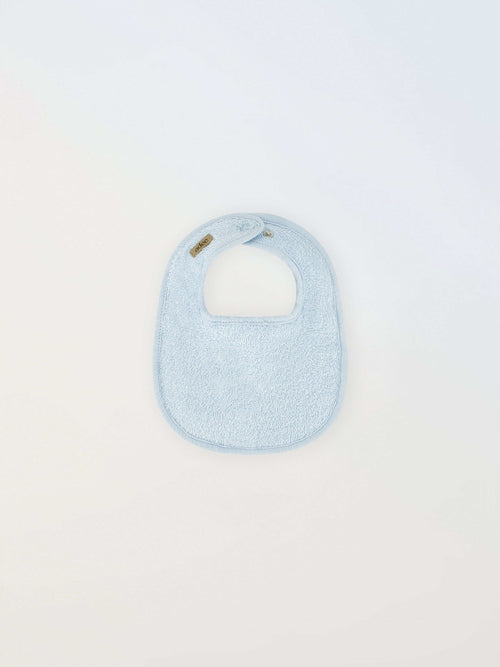 Small blue Adee bib for boys in terry cloth with brand tag visible