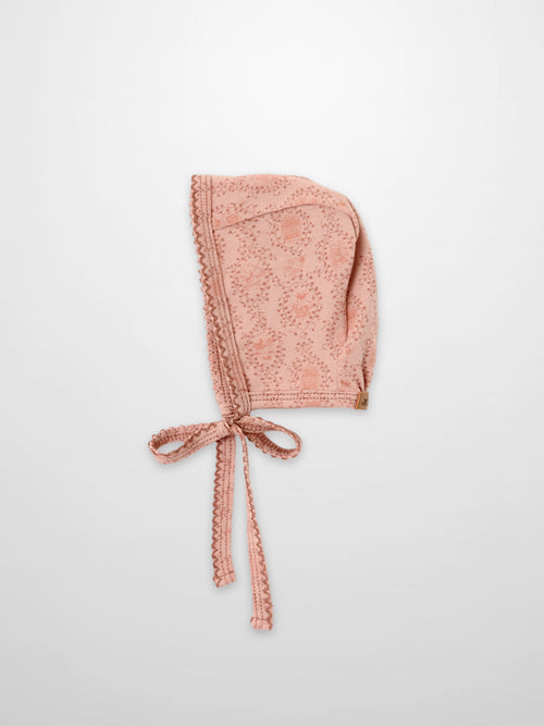Pink Charm Bonnet for girls by Adee, pink fabric with trailing vine pattern and ties.