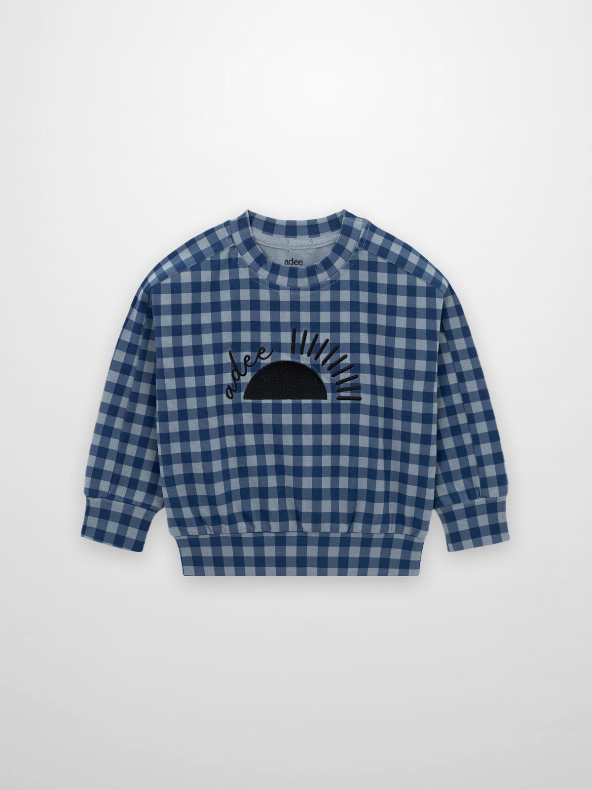 Blue gingham pajama top, long-sleeve, with black sun graphic on chest and ribbed cuffs.