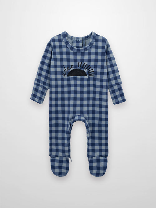 Blue gingham stretchy baby footie with sun motif and Adee script, back snaps and hidden inseam zipper.